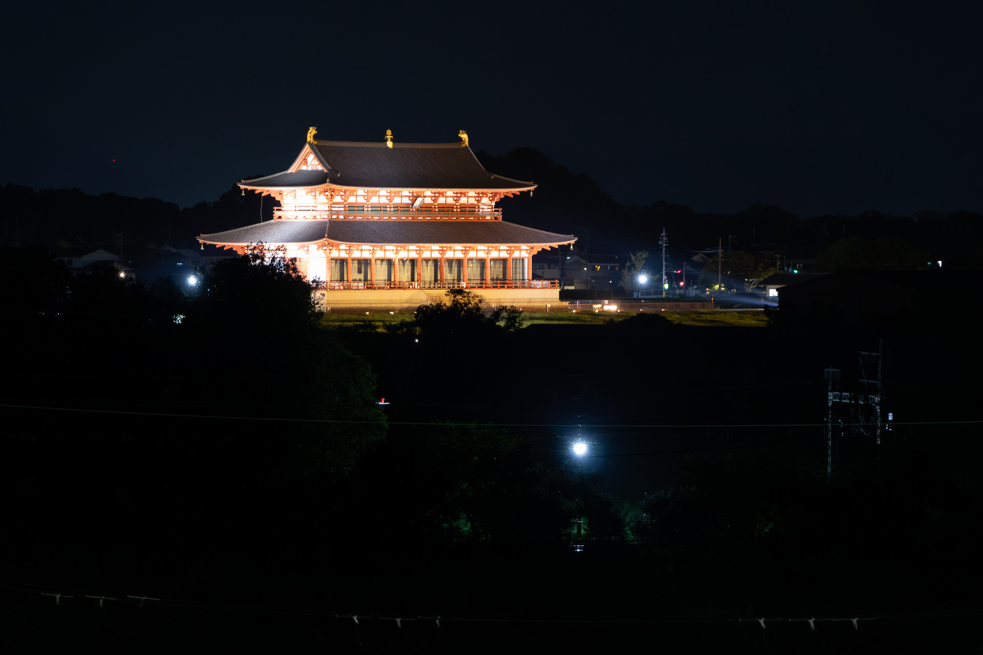 夜はライトアップされる第一次大極殿。朱雀門も同様にライトで照らし出されるので美しい。近鉄奈良線の架線がうっすらと見える