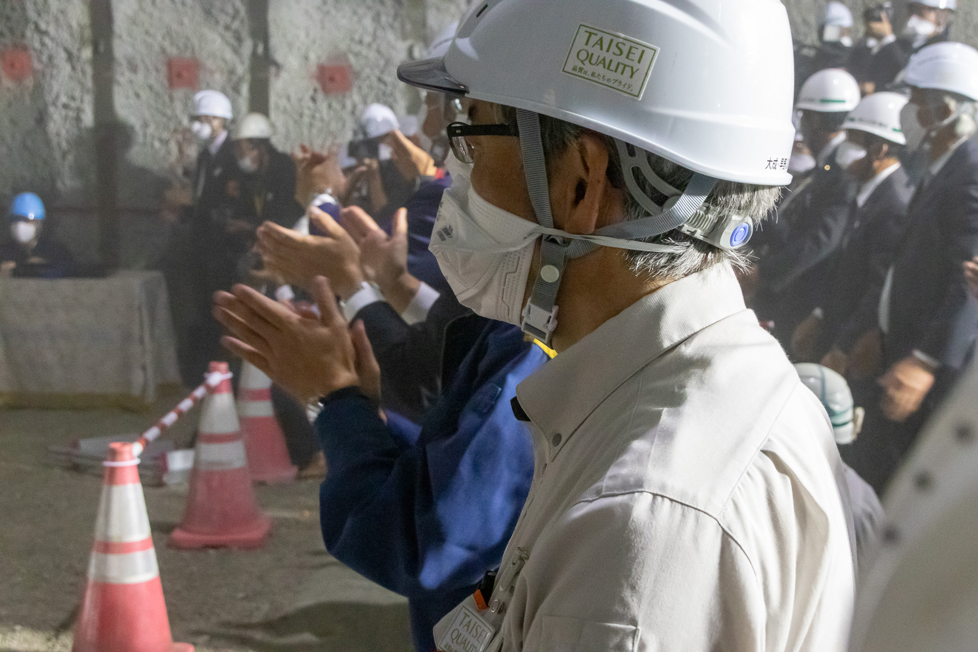 粉塵が舞うなか光が美しく差し込み、参列者は拍手で祝う