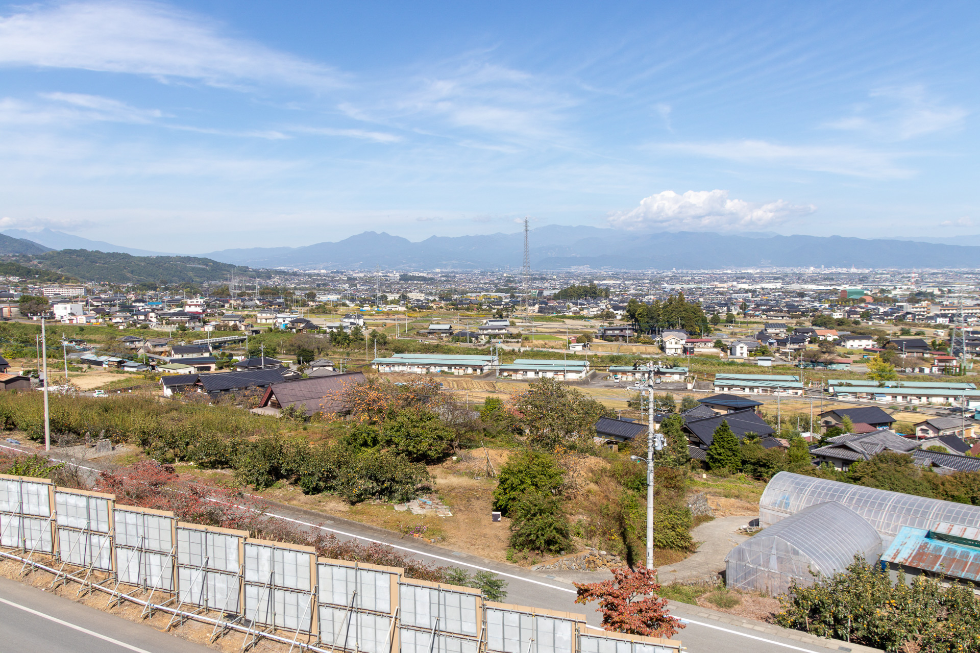 工事現場の展望台から甲府盆地を撮影したもの。中央に写っている鉄塔の奥に利根川公園部高架橋が見える