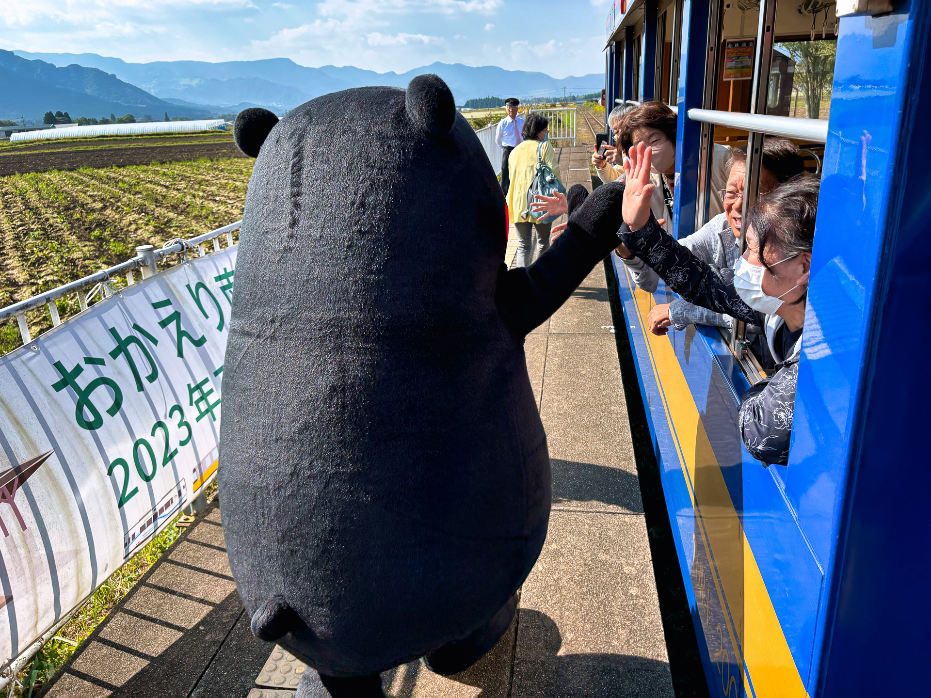 見晴台駅で降車したくまモン。隣の車両の一般乗客ともハイタッチするサービスぶり。手を振って見送る姿はかわいかった