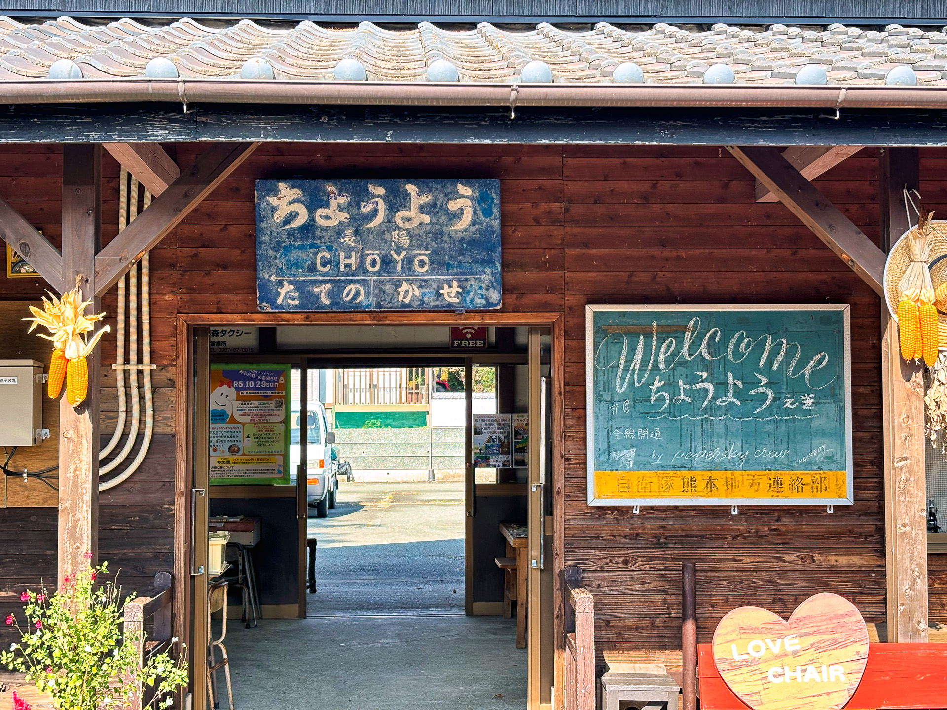 昭和2年に建てられたという長陽駅の木造駅舎。趣がある。この駅舎にある穴場カフェ「久永屋」の名物資本（シフォン）ケーキをユーモラスにPR