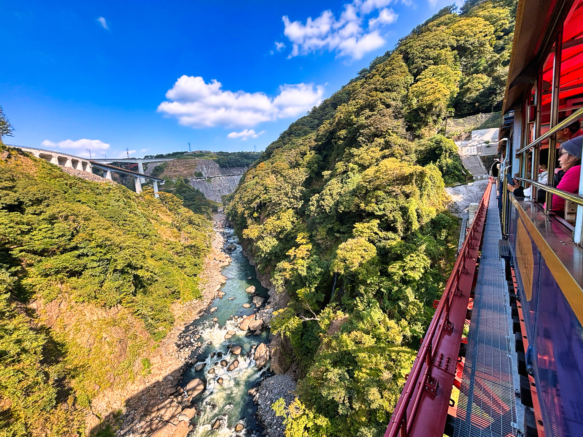 白川の流れと新阿蘇大橋などを望む、南阿蘇鉄道の絶景ポイントではトロッコ列車が止まってくれた。息を飲むスケール感だ