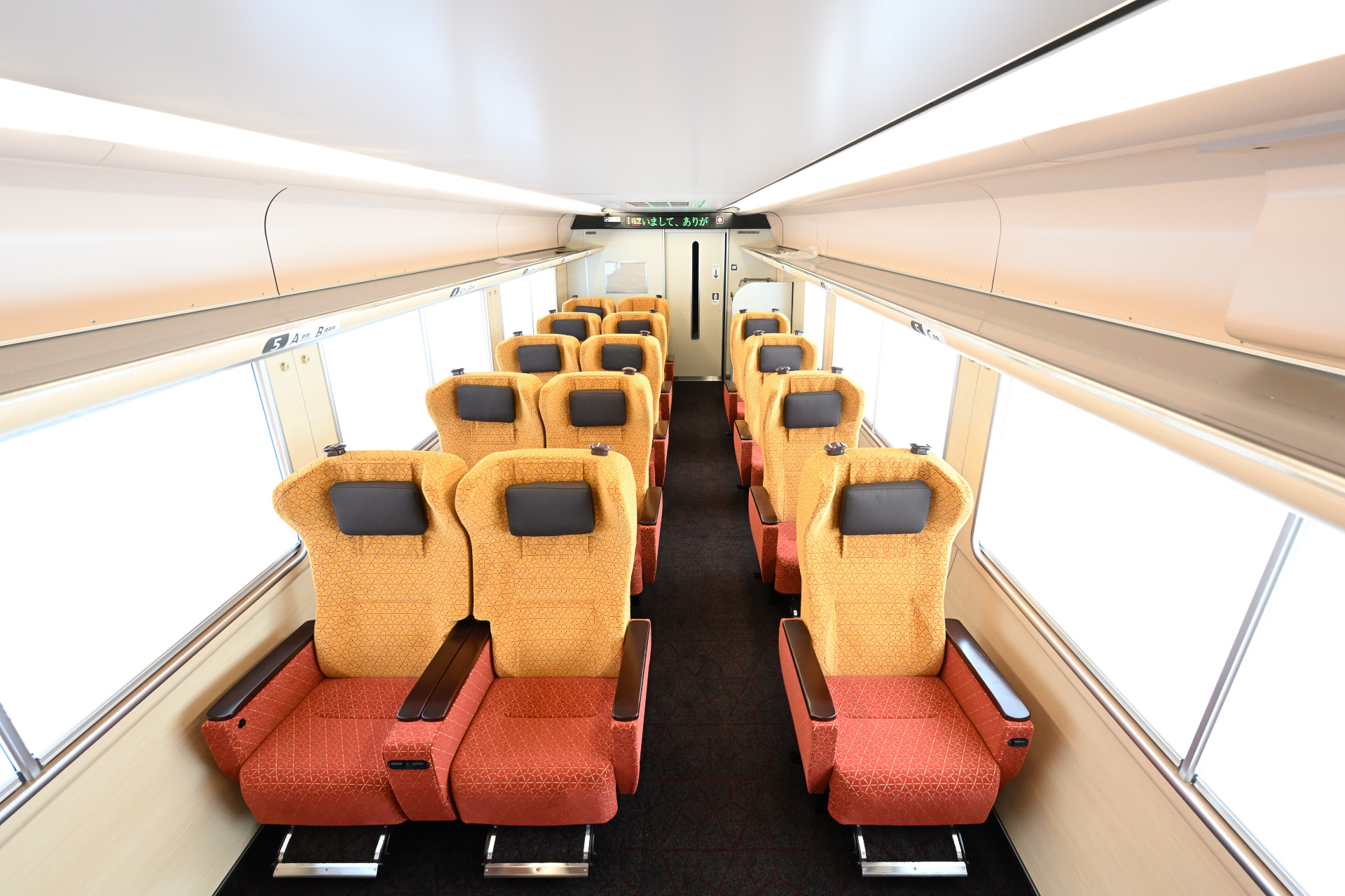 明るく空間の広がりを感じられる黄色がベースとなったグリーン車車内