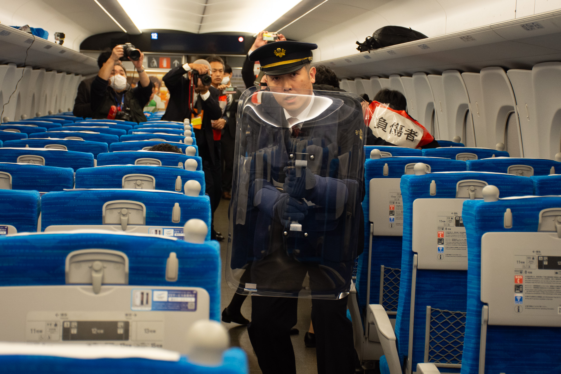 今度は前方11号車からシールドを持った車掌が客室へ