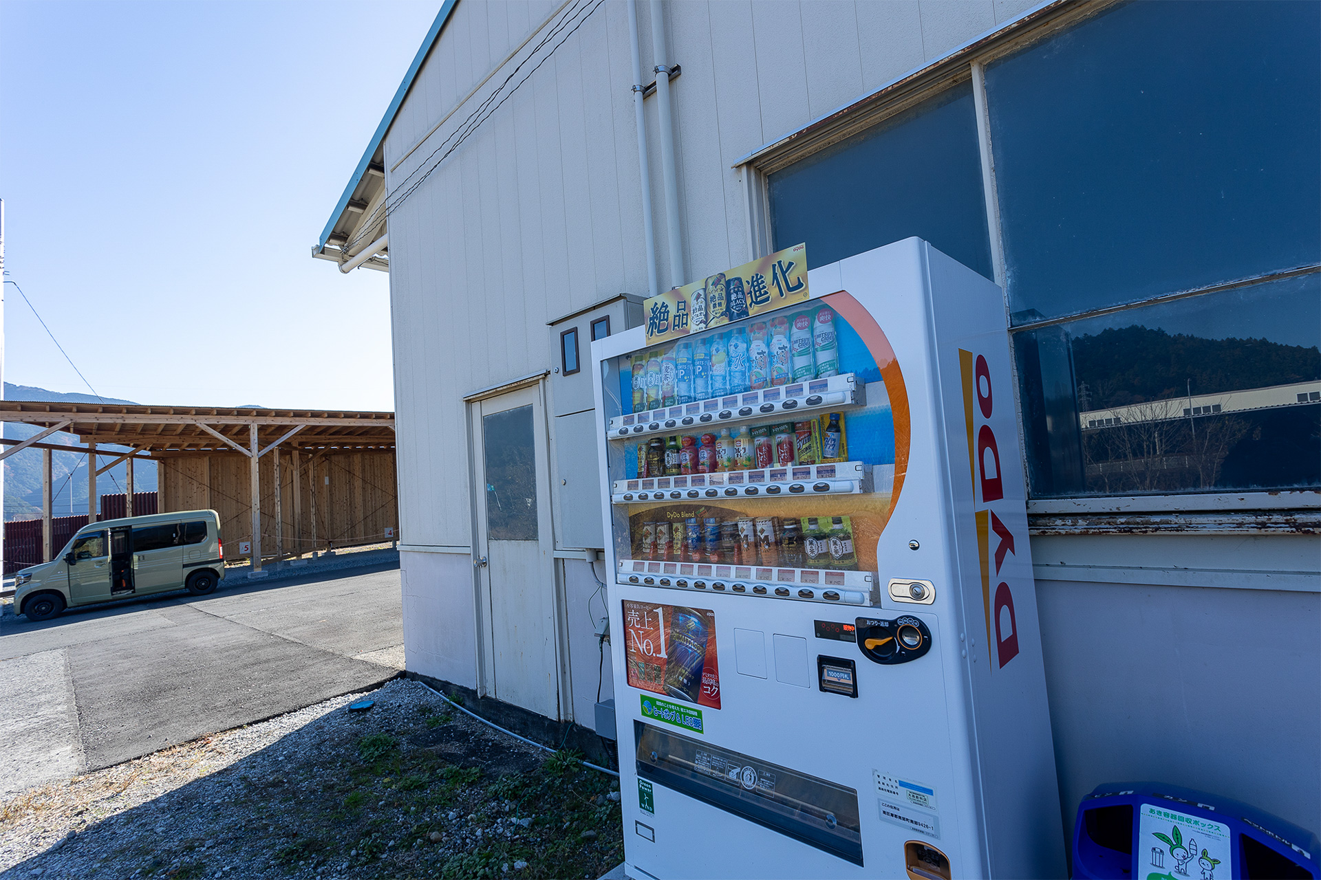 施設の横の倉庫前に飲料水の自動販売機がある