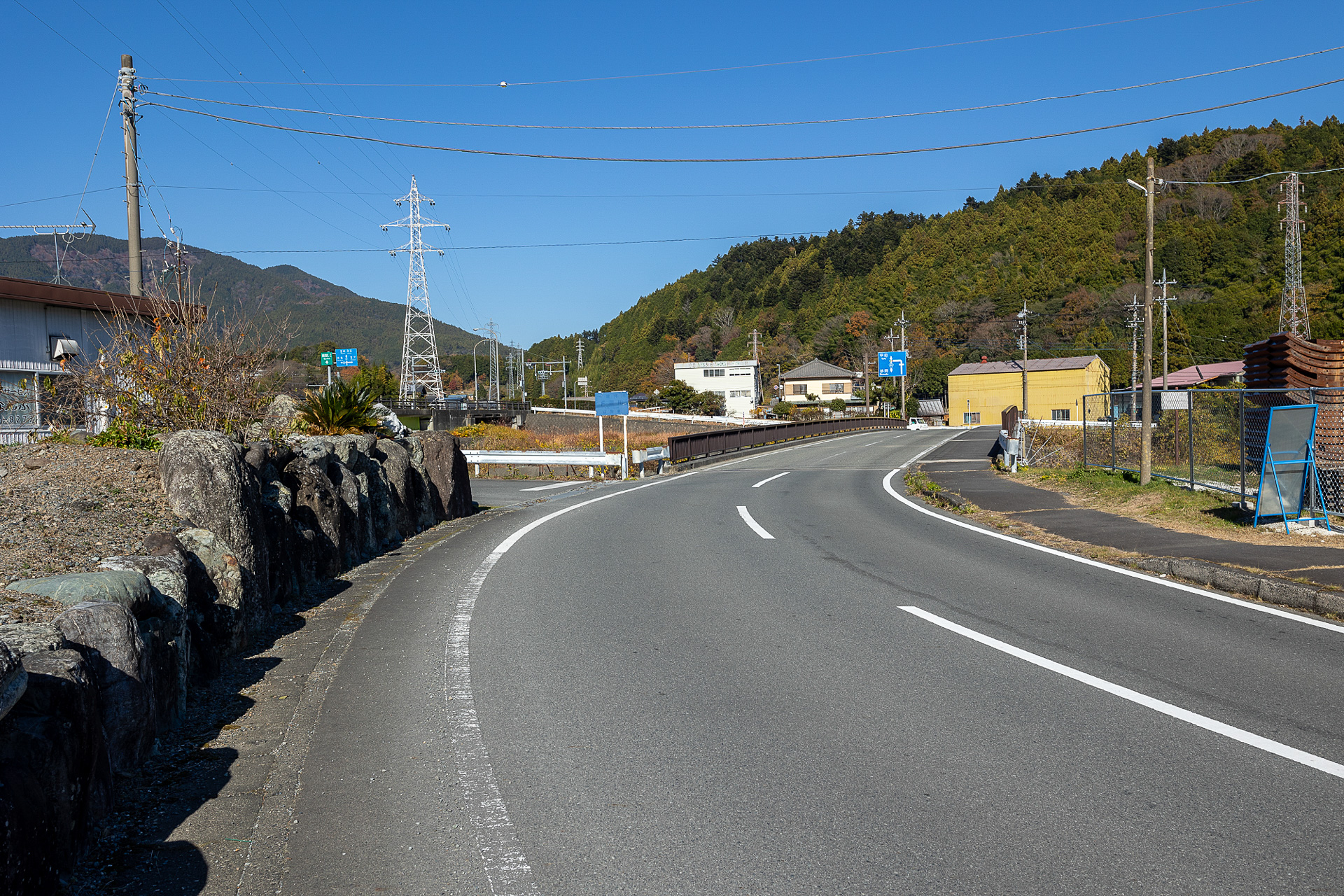 内船駅に寄ってからくると、この風景。国道の橋と並ぶ小さい橋、そして石積みの壁（白い建物がある）が目印。壁と橋の間を左へ曲がる。なお、内船駅方面から来る途中に稲葉工業があり、稲葉工業の隣にはオギヤというスーパーがある