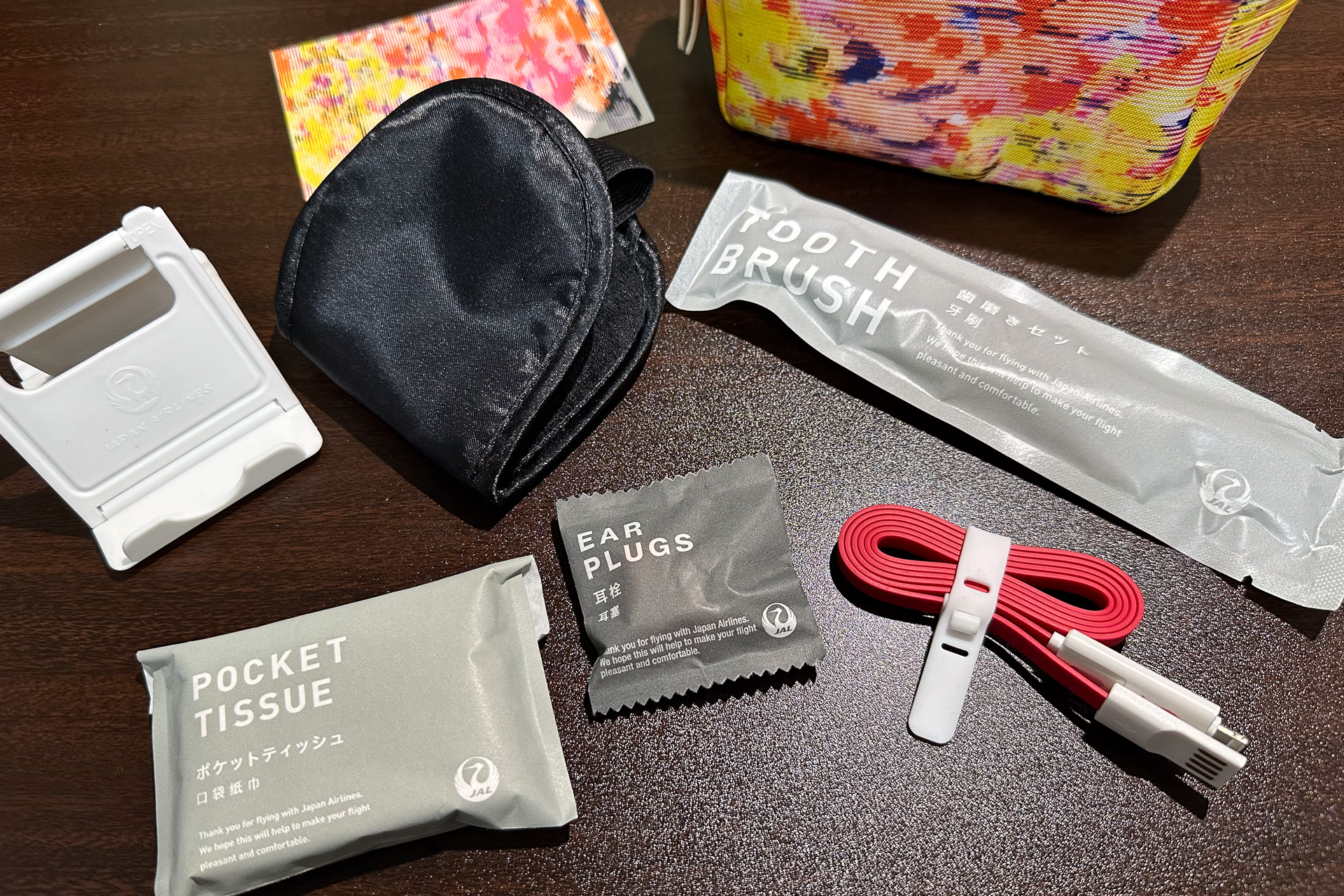アイマスク、耳栓、ポケットティッシュ、歯ブラシ、折りたたみ式スマホスタンド、スマホ充電ケーブル
