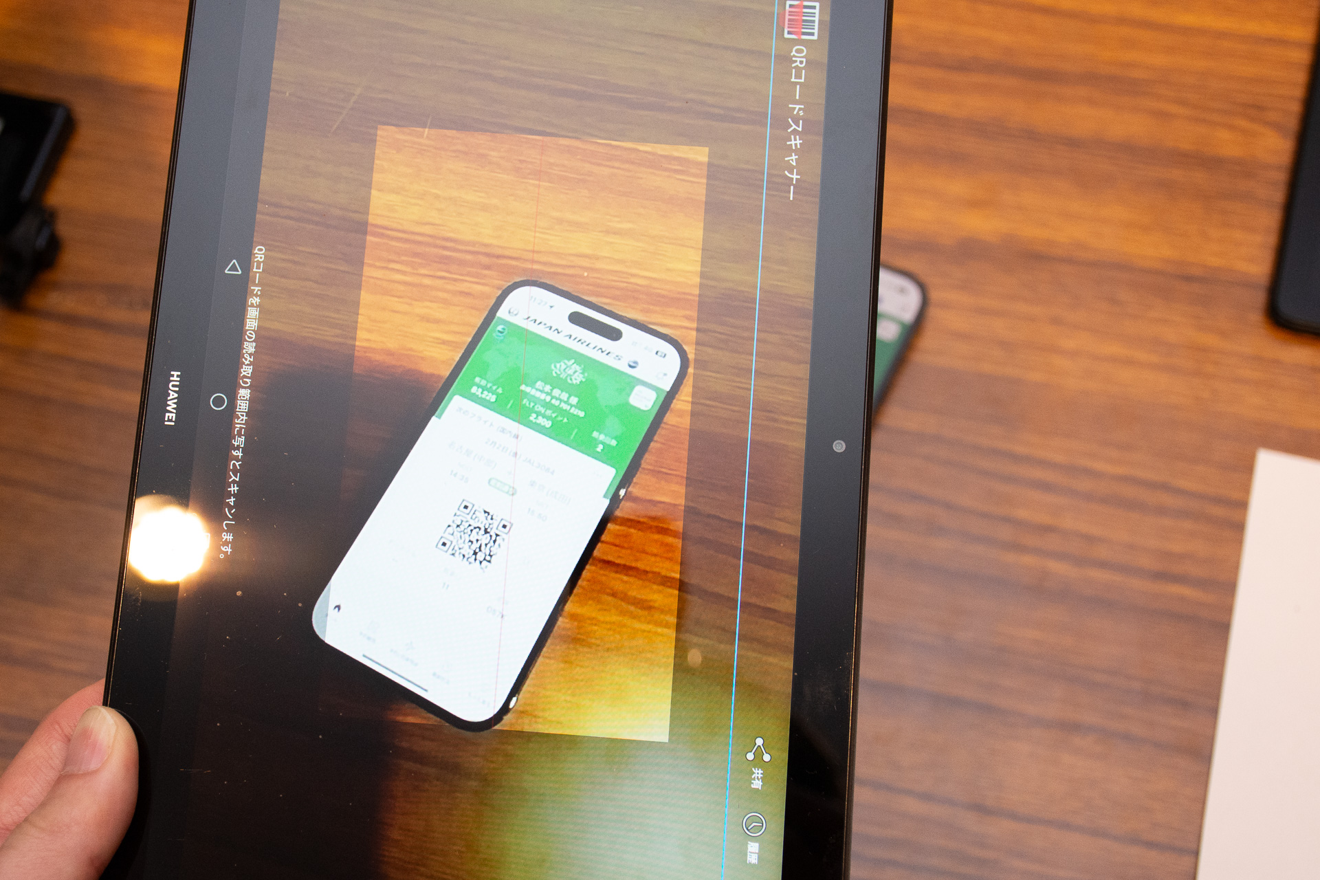 スマートフォンのエアラインアプリを開いて搭乗券QRコードを読み込む