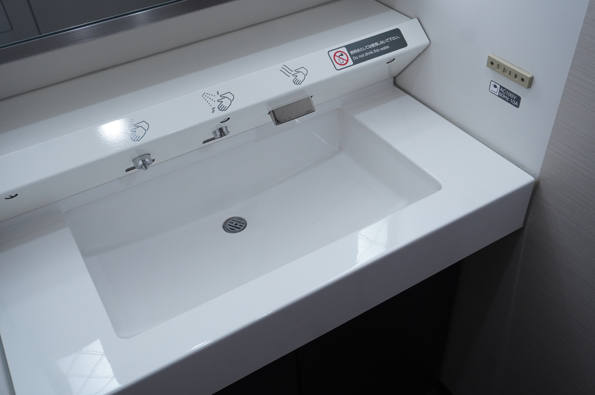 各車両内には大型荷物置場。その分、デッキのトイレと洗面台は広々