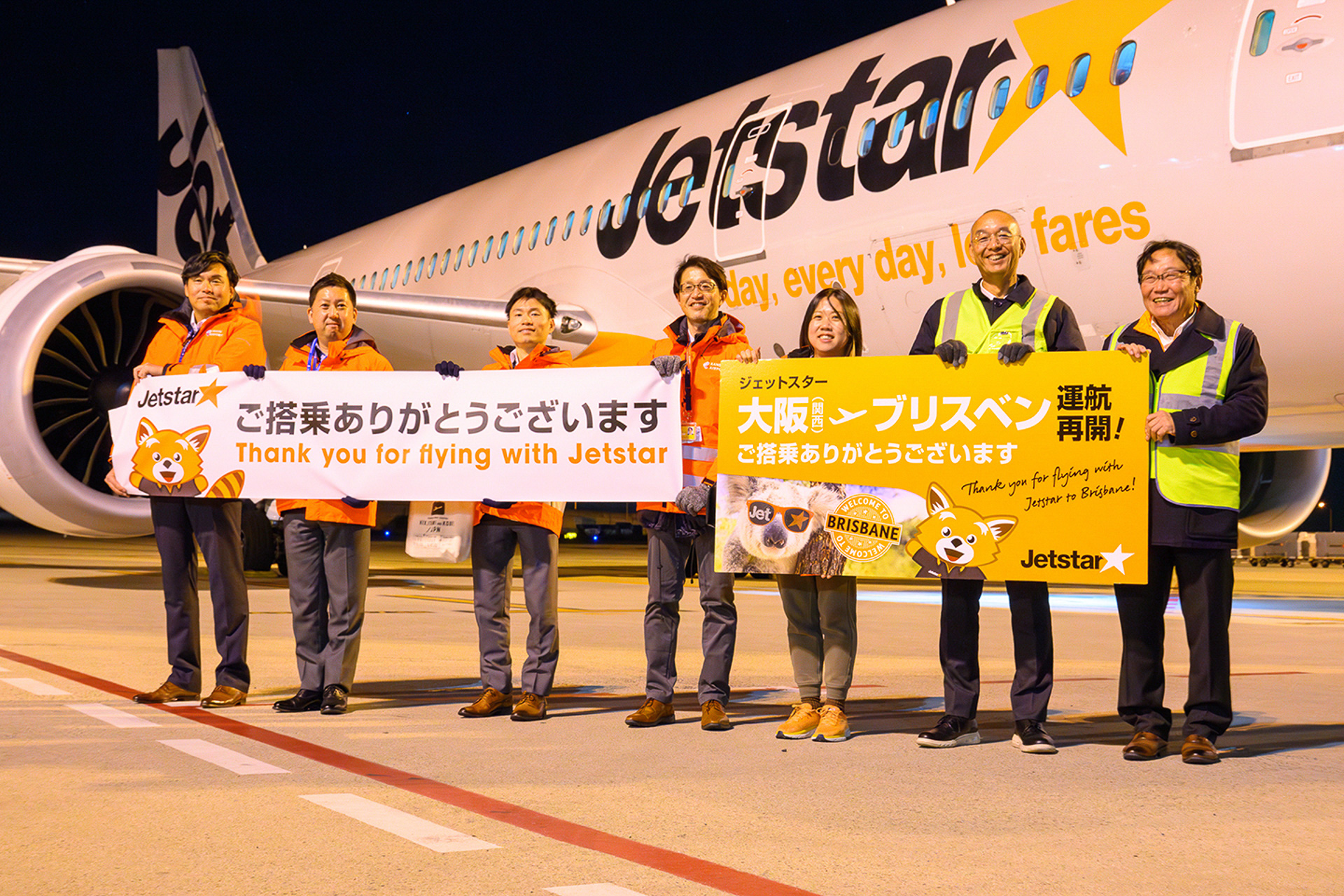 ランプで報道陣のカメラ撮影に応じるジェットスター、関西エアポート、スイスポートジャパンの職員たち