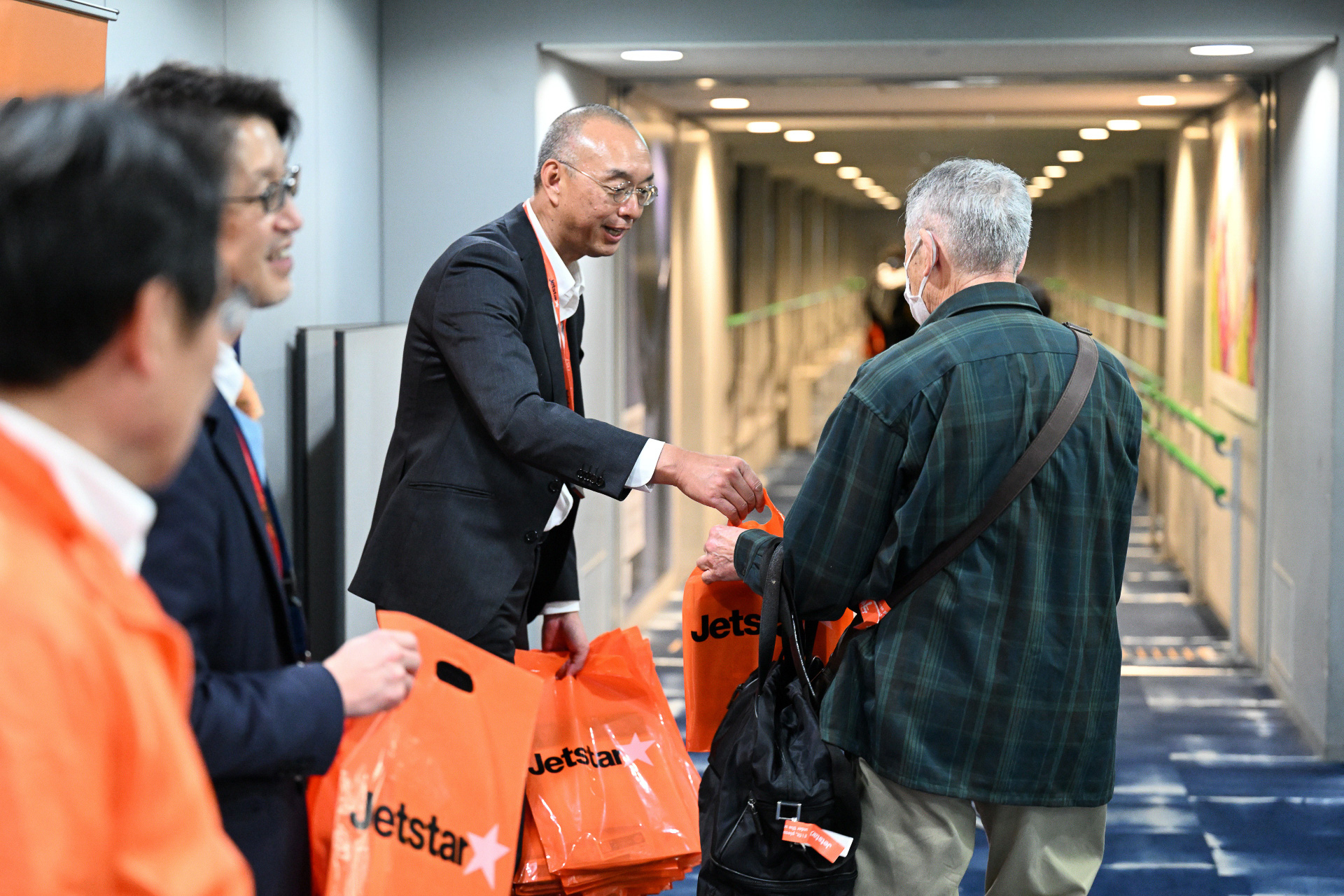 ジェットスター航空 日本支社長の横田敏章氏も乗客に記念品を手渡す