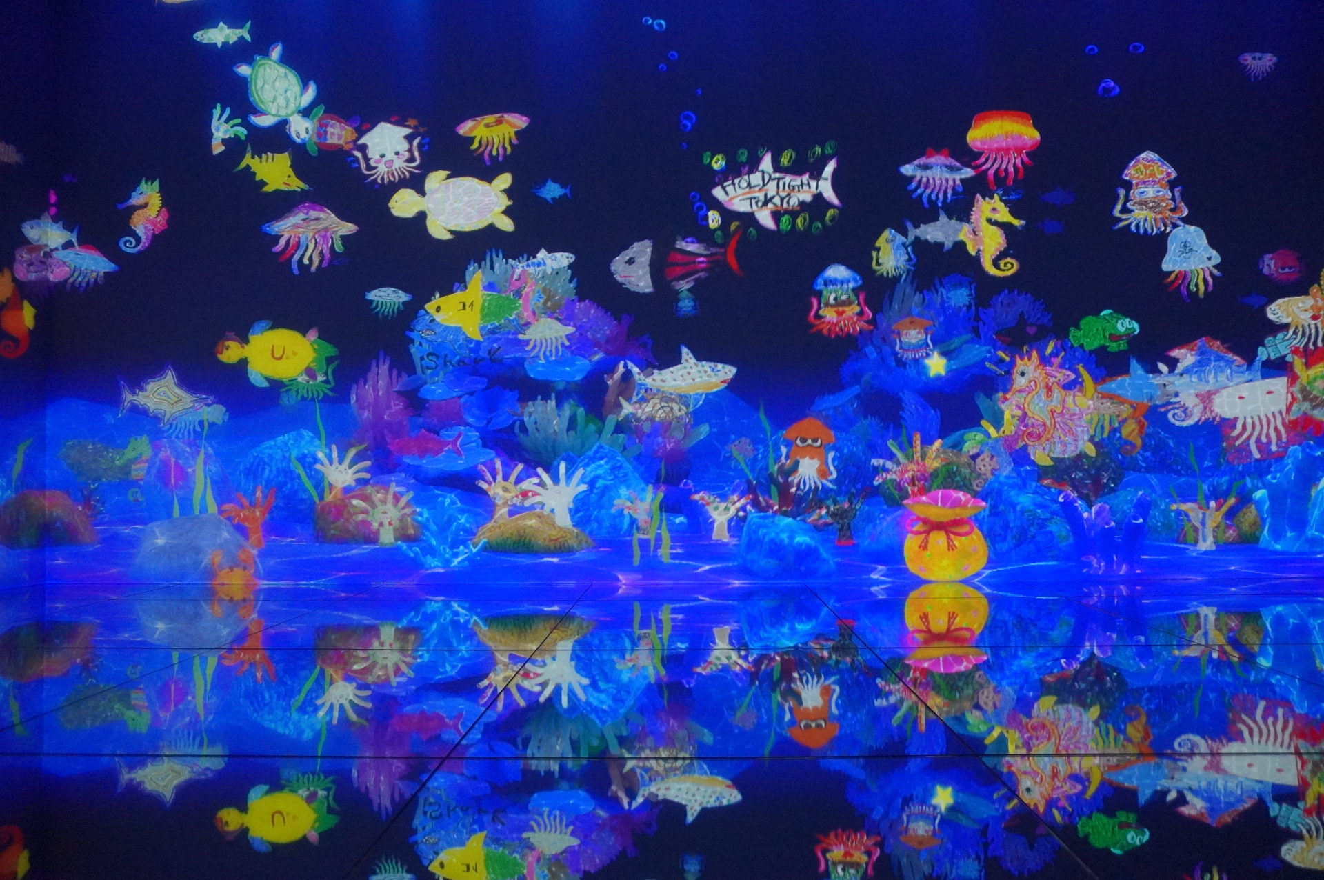 自分で描いた絵が壁一面の水槽のなかで泳ぎだし、作品の一部に加わる