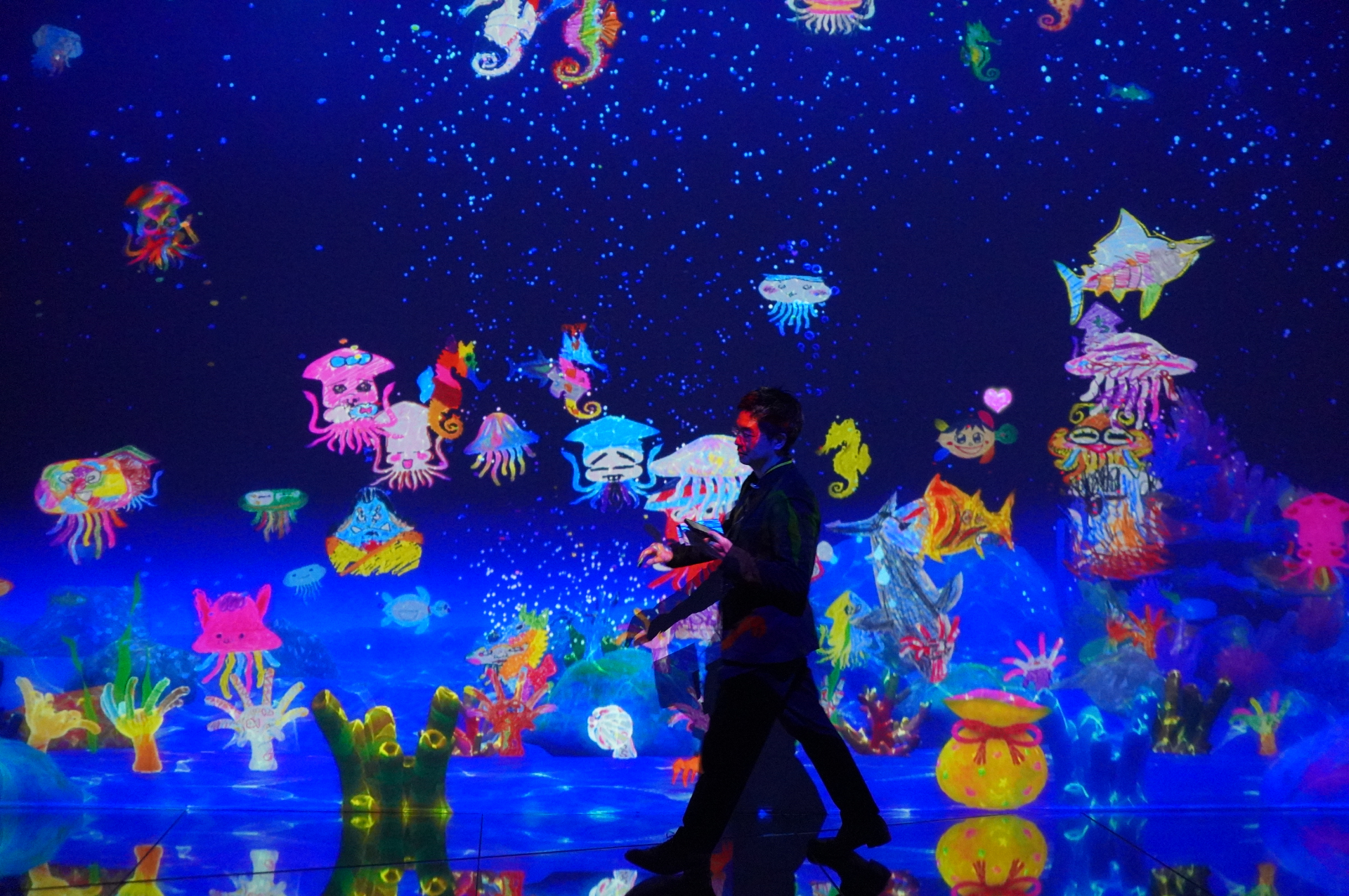 自分で描いた絵が壁一面の水槽のなかで泳ぎだし、作品の一部に加わる