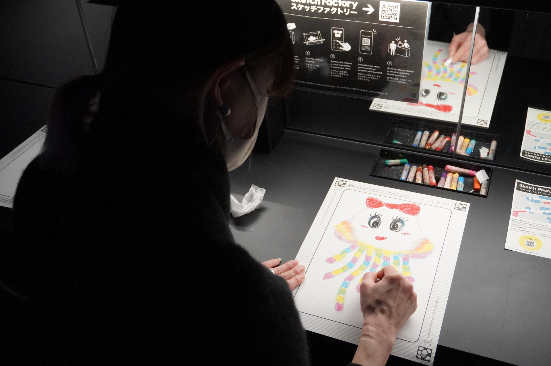 自分で描いた絵が壁一面の水槽のなかで泳ぎだし、作品の一部に加わる