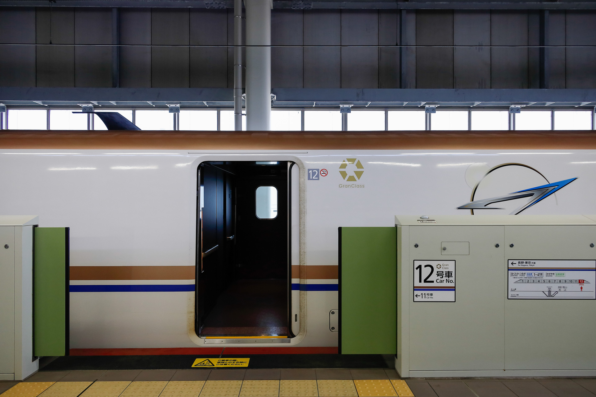 可動柵を設置した新幹線駅の例（北陸新幹線・金沢駅）。開口の横に号車番号が書かれている様子が分かる。その右手には編成全体の並びも示している