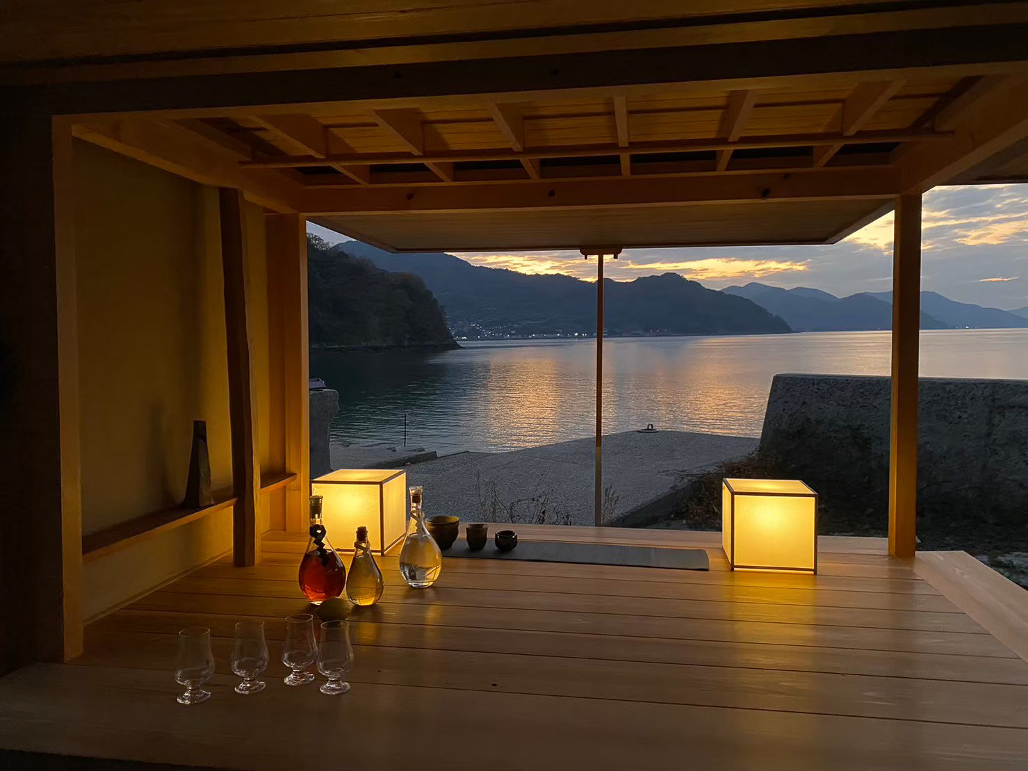 水平線に沈む夕日を眺めながら波の音をBGMに乾杯（Kagiyama Gallery Barの移動式数寄屋建築、施工：杣耕社、設計：高原正伸建築設計事務所）