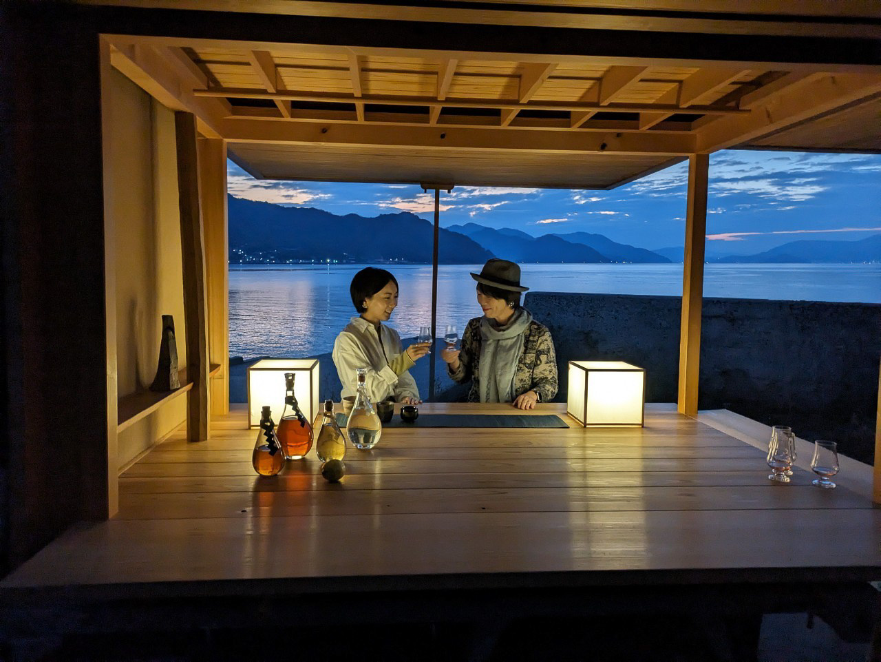 水平線に沈む夕日を眺めながら波の音をBGMに乾杯（Kagiyama Gallery Barの移動式数寄屋建築、施工：杣耕社、設計：高原正伸建築設計事務所）