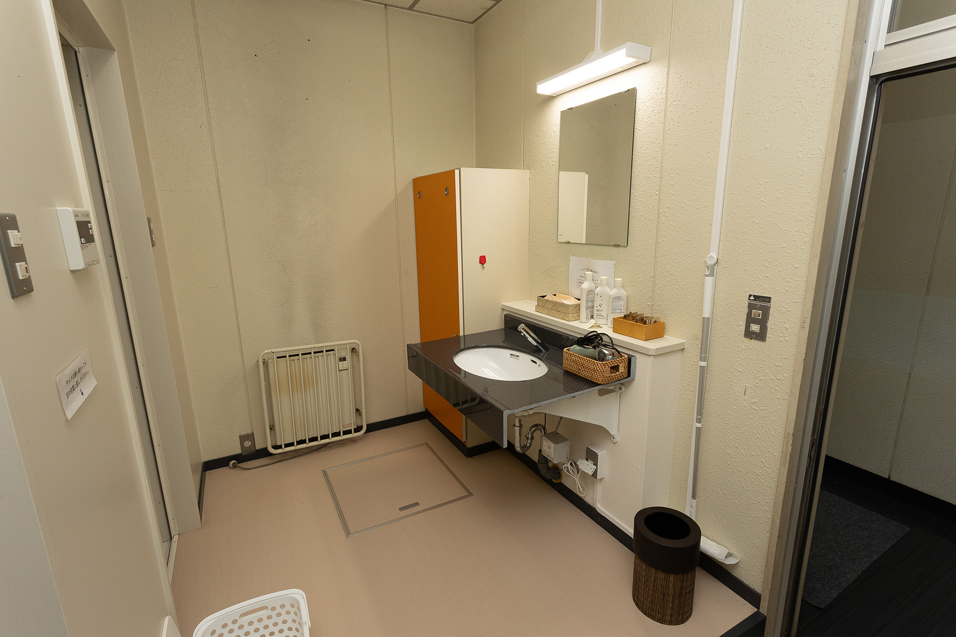 男性用のシャワールーム。脱衣所には鏡と洗面台がある。ドライヤーも置かれていた