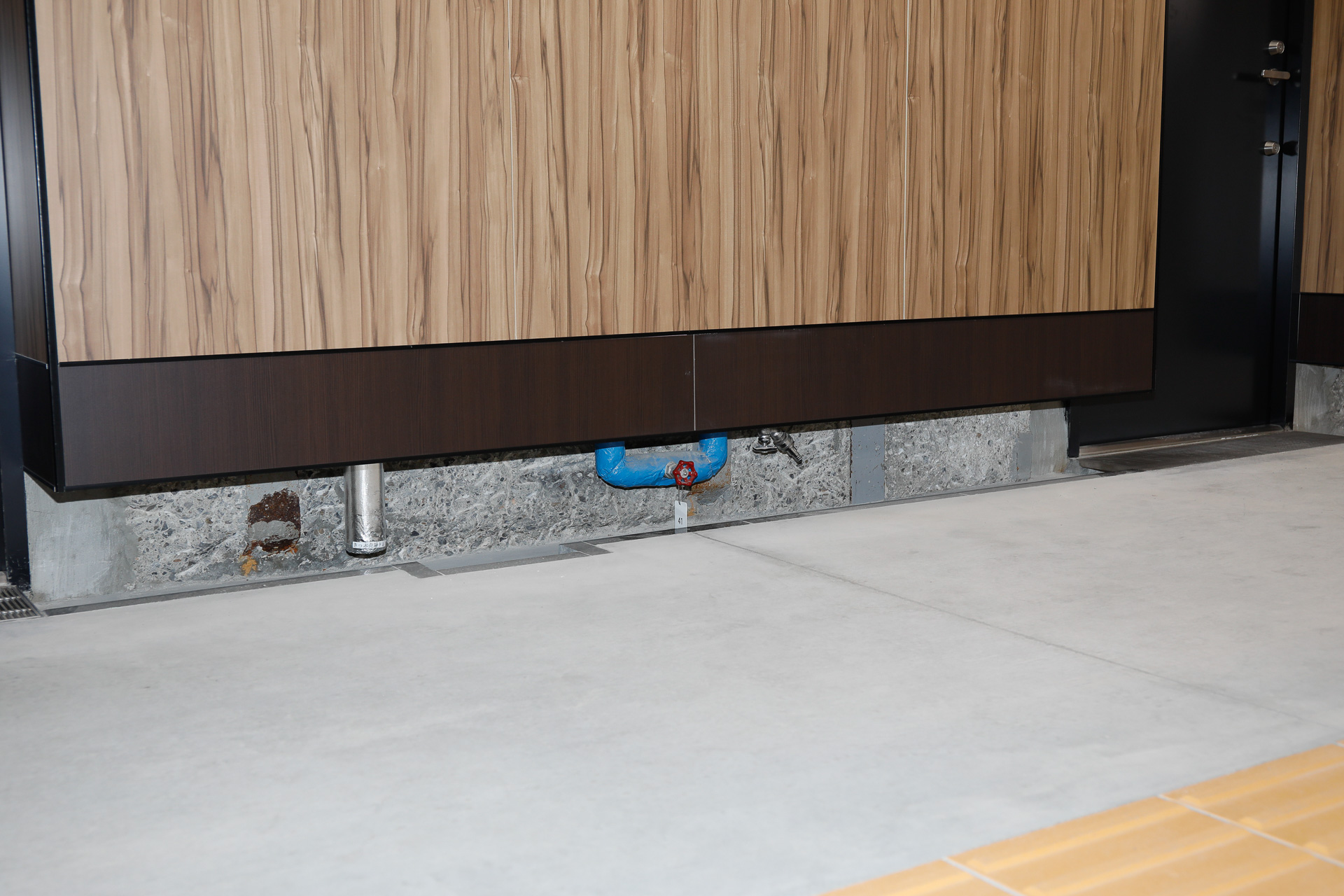 通路の左右両端に排水溝が設けられているが、その上に壁が張り出している構造がおもしろい