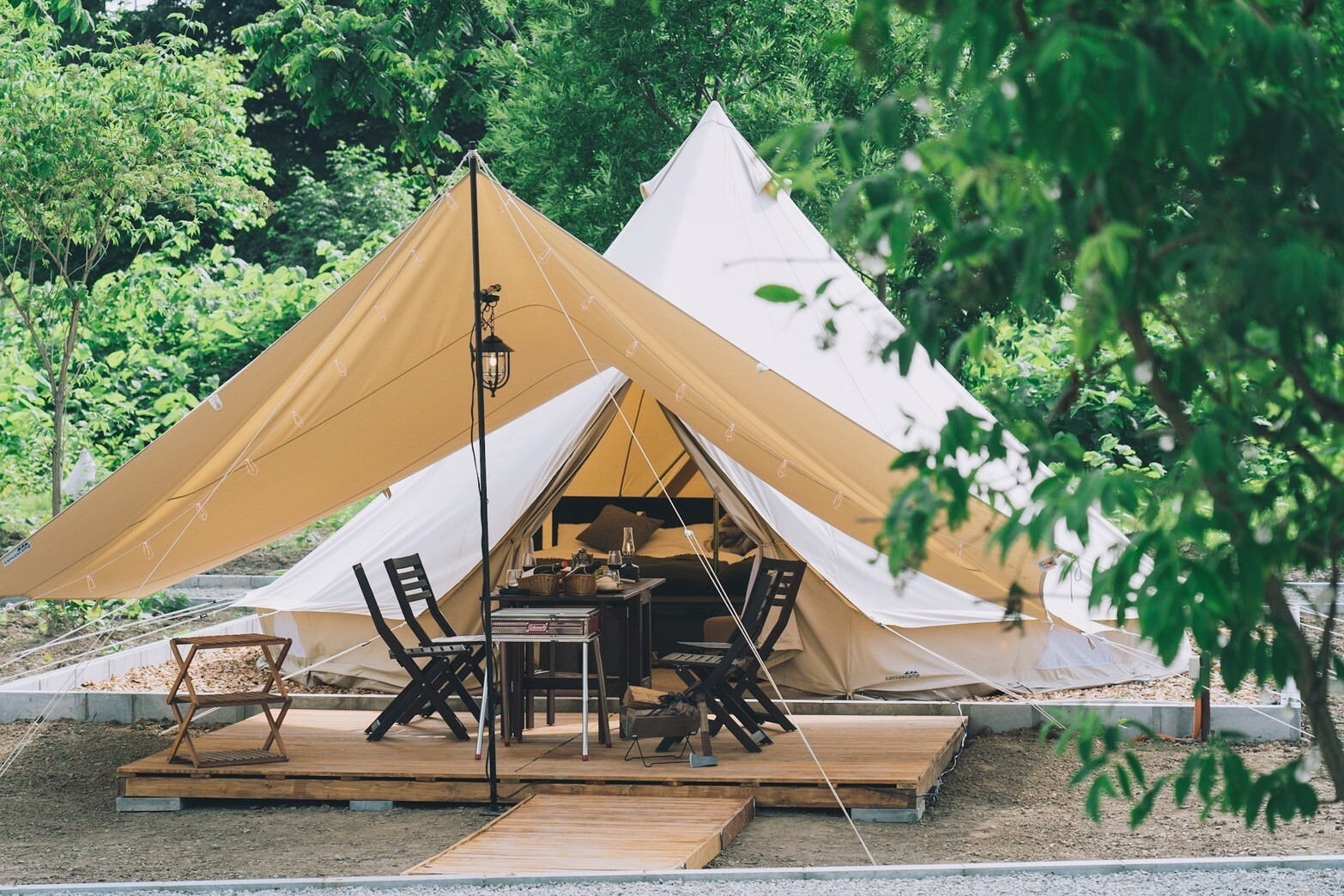 屋内外にテーブルなどを配した「コットンベルテント」。定員4名から2名に対応する全12室がぶどう畑の自然に立つ