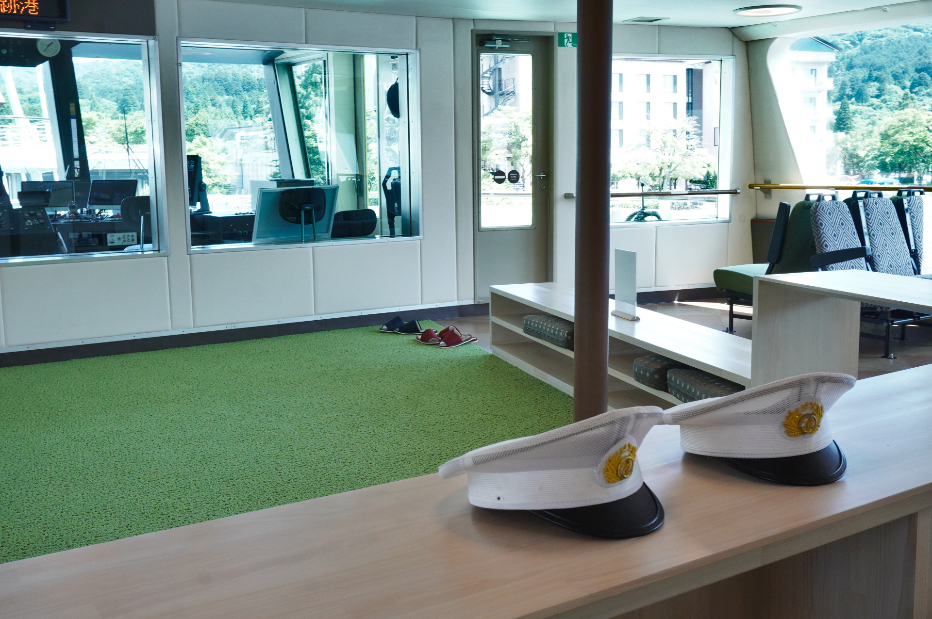 大きな窓越しに操舵席の様子が見られる。船長になりきれる制服のキャップも用意