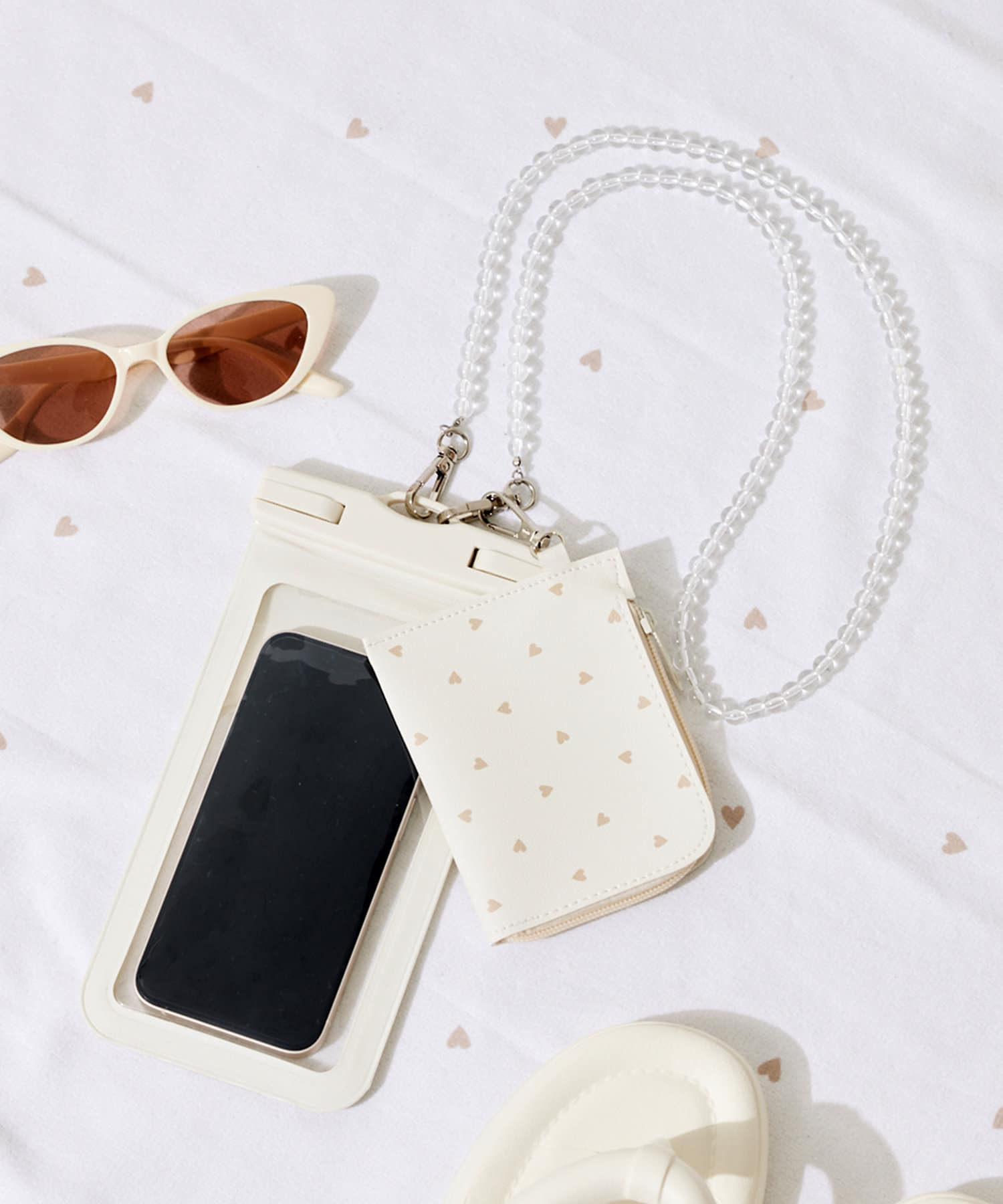 「ポーチ付き防滴スマホケース」（550円）は、取り外しできるビーズストラップ＆ミニポーチ付き