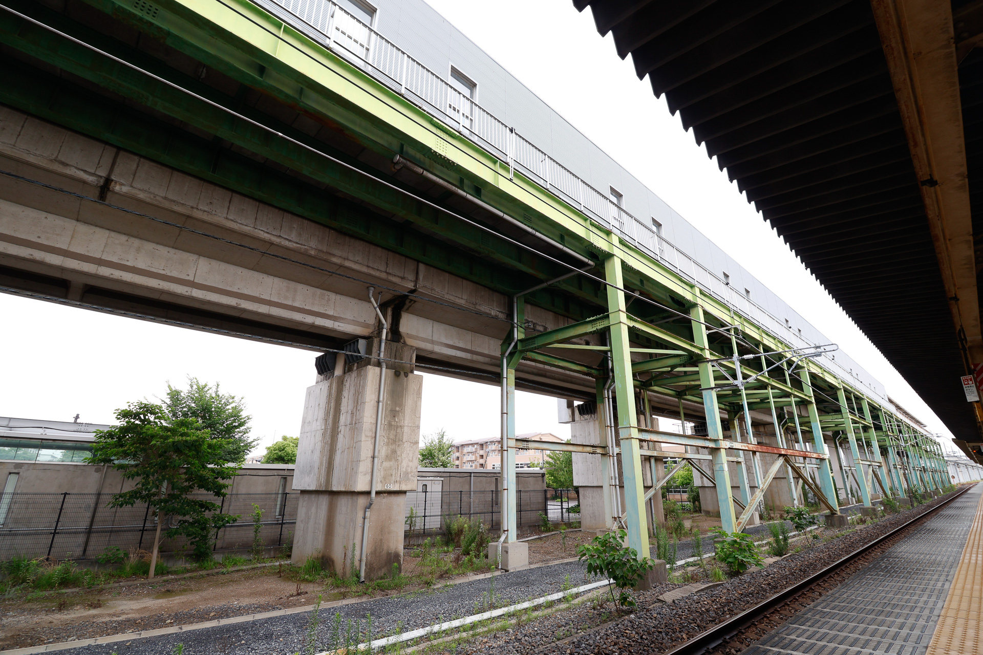 東鷲宮駅の下りホームから見上げた上りホーム。先に高架の上り線ができて、そこにあとからホームを設置して旅客駅とした関係で、コンクリート製の高架橋に、鉄骨で支えるホームが沿う構造になっている