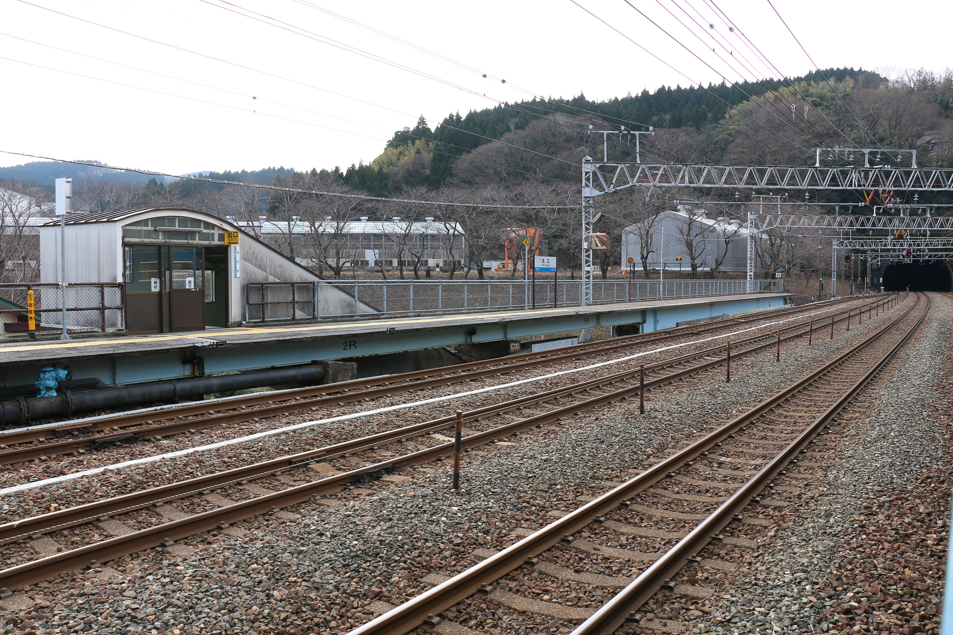 名立駅。右手の、ホームの下にある青い鉄骨部材の幅が広がっている辺りが名立川橋梁。それをまたぐ形でホームが前後に延びている