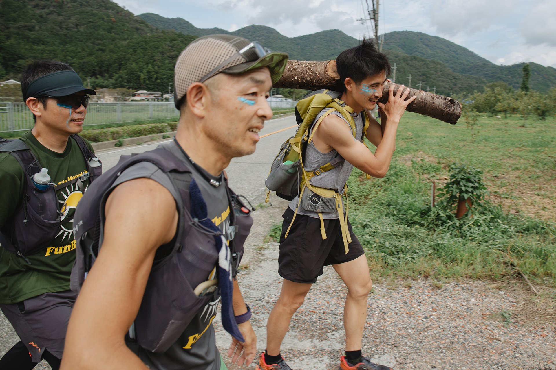 伐採した丸太を担いで走る参加者