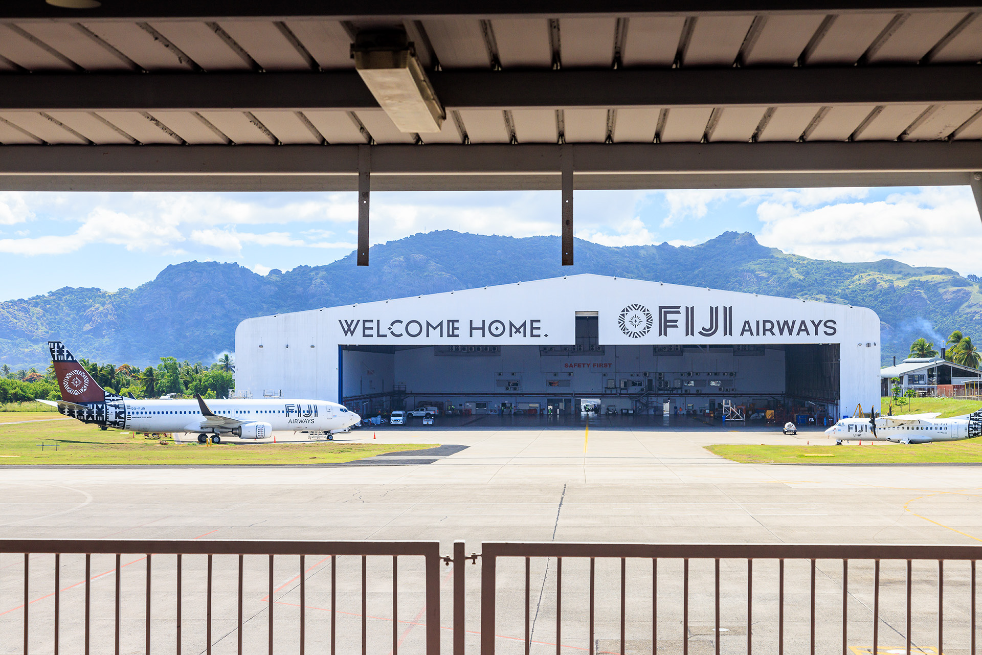 搭乗口からボーディングブリッジへの通路から格納庫が見える