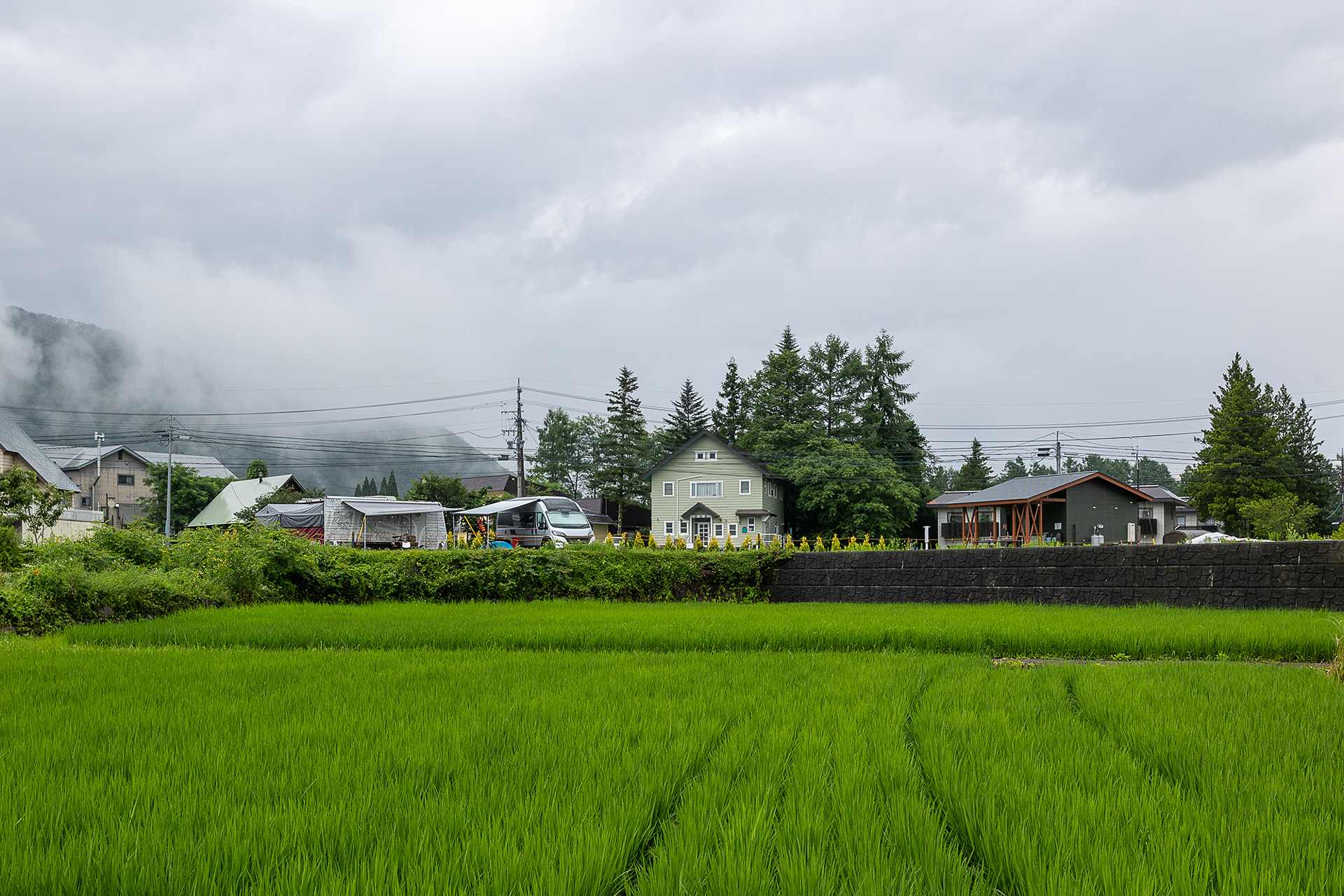 山側に道路から施設を見た様子。夏でも夕方から涼しくなって夜は20℃を下回る。寝るときはエアコン要らずどころか、春秋用のシュラフや掛け布団が必要だ