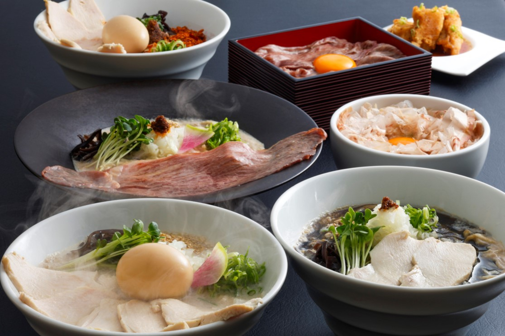 牛骨スープと関西風の和出汁を融合したらーめん 牛骨の王。焦がしニンニクオイル入り「BLACK黒王」や特製スパイス入り「SPICY赤王」などのメニューも