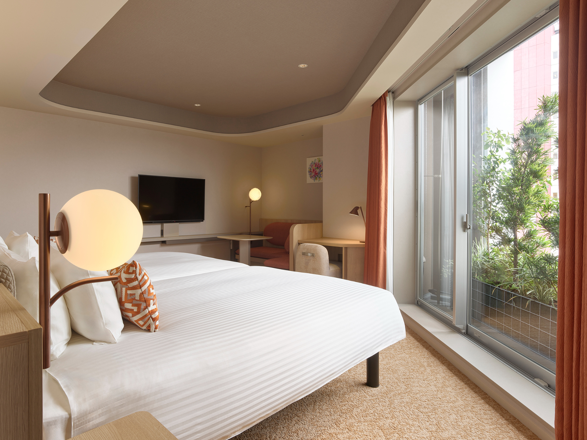 定員2名の「デラックスコーナーツイン」（39.3m<span class="em sup">2</span>）。バルコニー付きの大きな窓からは、築地や銀座の街並みを望む