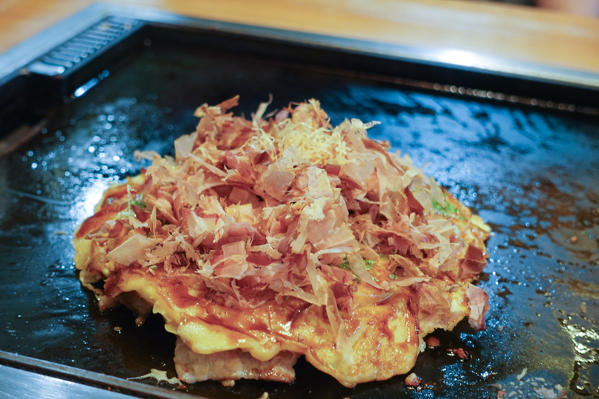 宗田節をたっぷりかけたお好み焼き。特性の木箱に入れて提供する