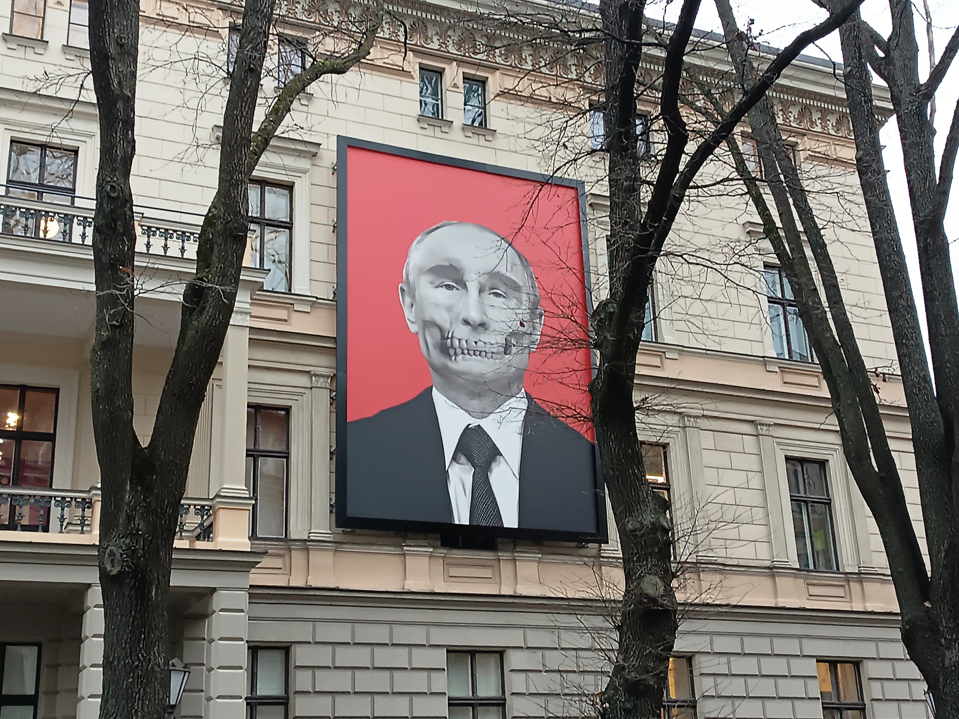 リガのロシア大使館前には反ロシア派の掲げたウクライナの国旗と、隣の医学史博物館の壁にはロシアのプーチン大統領の顔にドクロを合わせて描いた巨大なポスターが