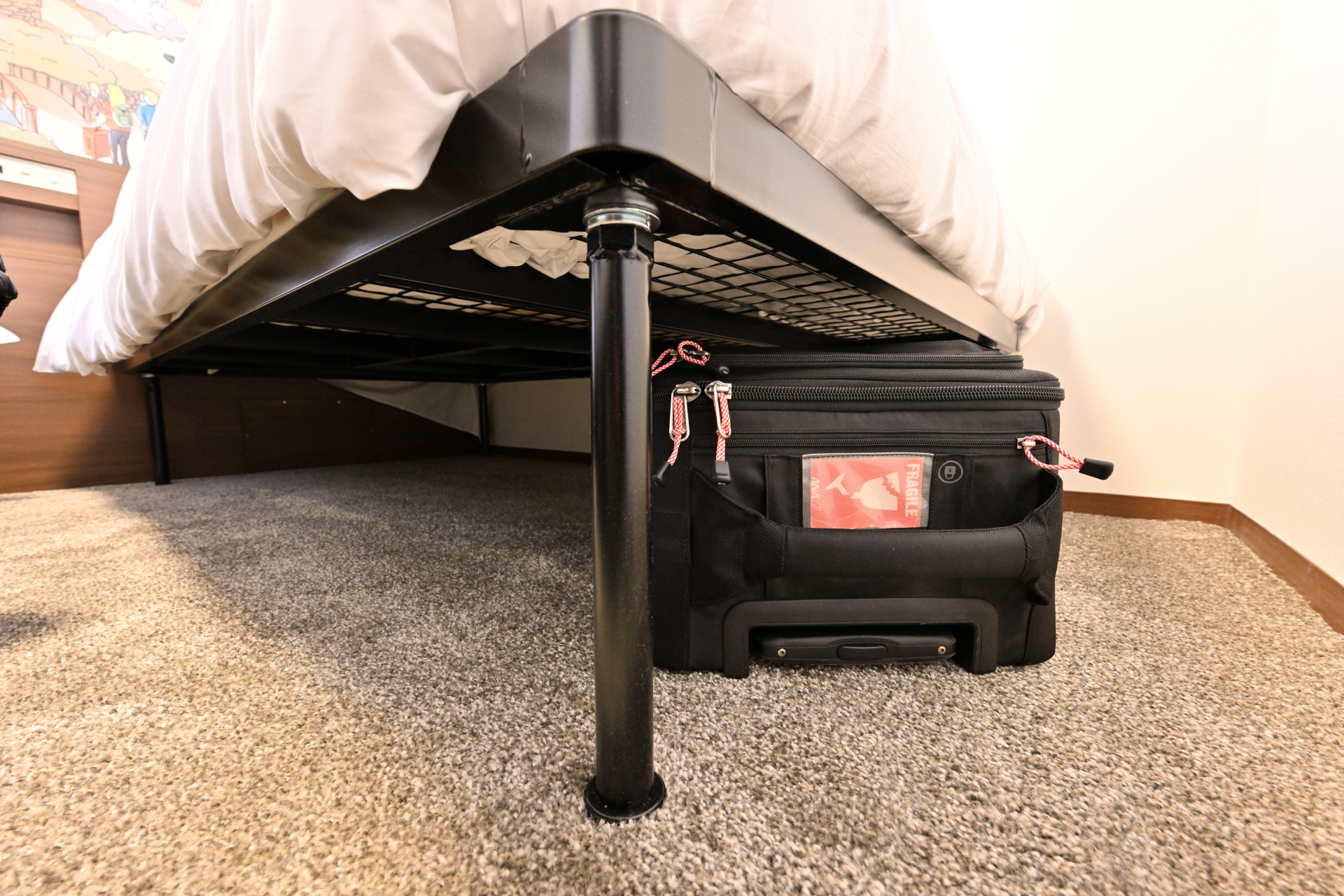 ベッド下を収納として利用することで、大きな荷物による窮屈感をなくす工夫がされている。大型スーツケースでも十分に収納が可能