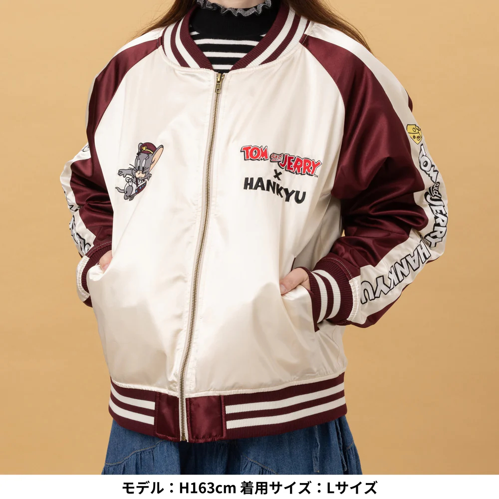 前面には阪急電鉄コラボのロゴとタフィーを、背面にはトムとジェリーたちが追いかけっこをしている様子を刺繍でデザイン