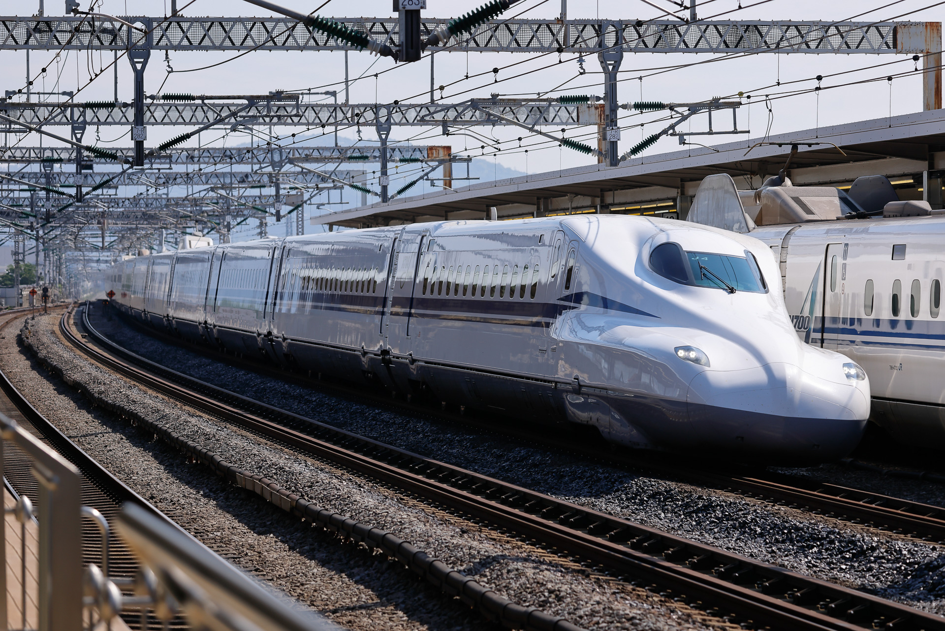 「こだま」を待避させて小田原駅を通過する「のぞみ」。単に停車するだけならそれほどでもないが、待避が加わると停車時間が伸びて、所要時間の増加につながる。とはいえ、東海道新幹線ではその増分をギリギリまで抑えている