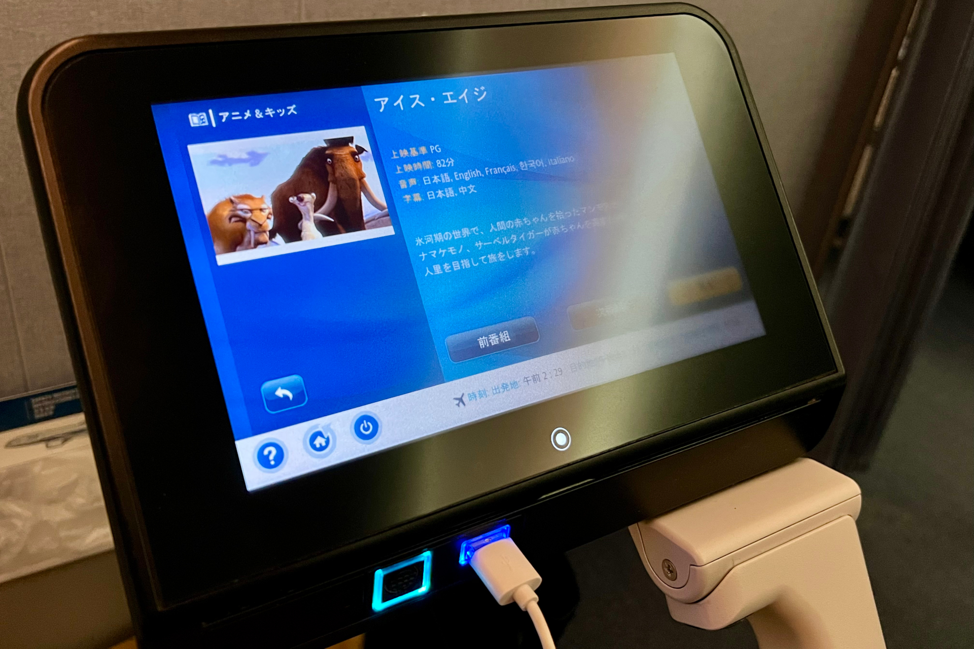 バルクヘッド席の個人モニターと食事テーブルは、アームレスト部分に格納されている。目の前の壁には機内安全ビデオやフライトマップが流れるモニターと個人専用収納ポケット