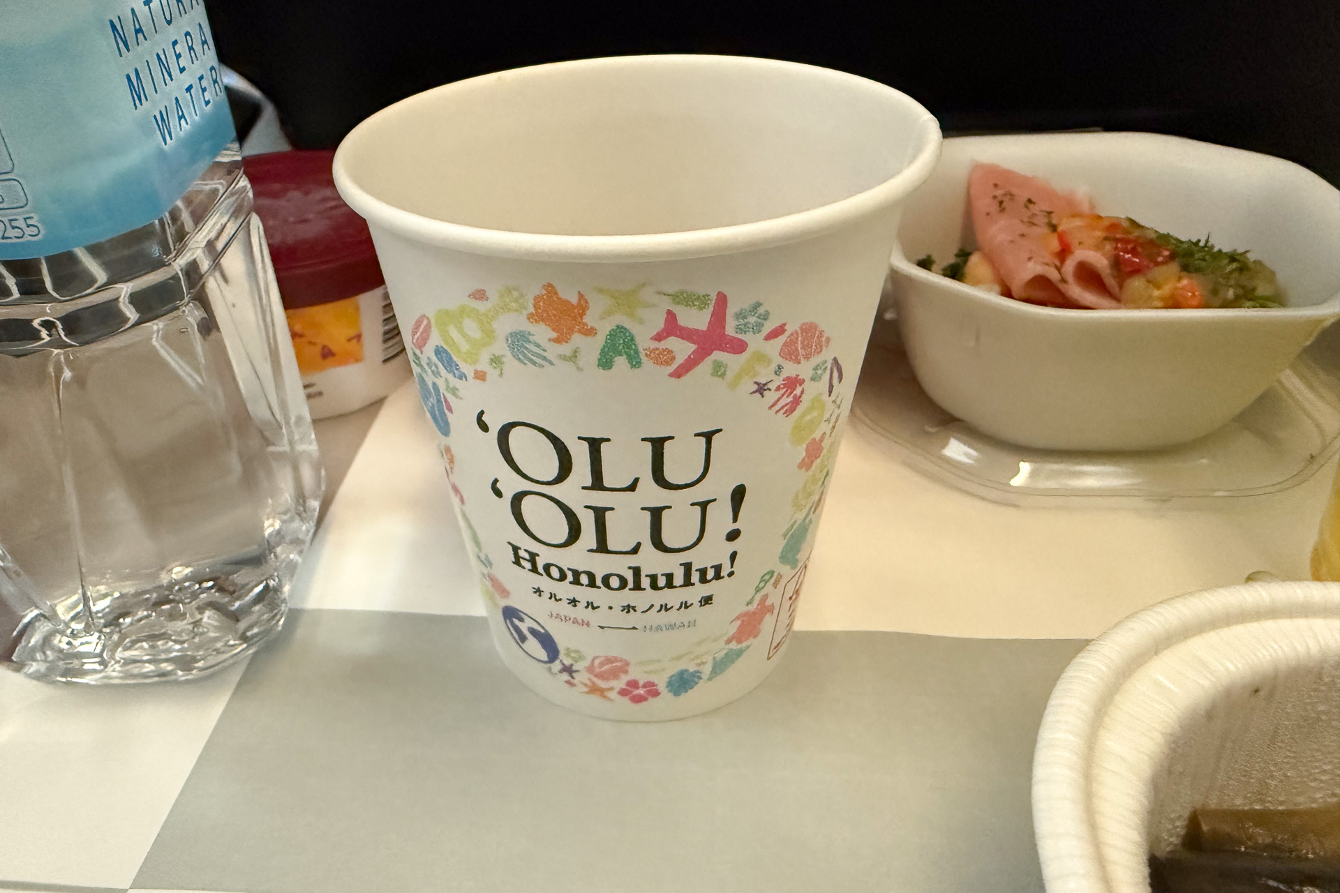 ハワイ線の機内ではスナックの包装や紙コップに'OLU'OLU! Honolulu!のデザインを施していた