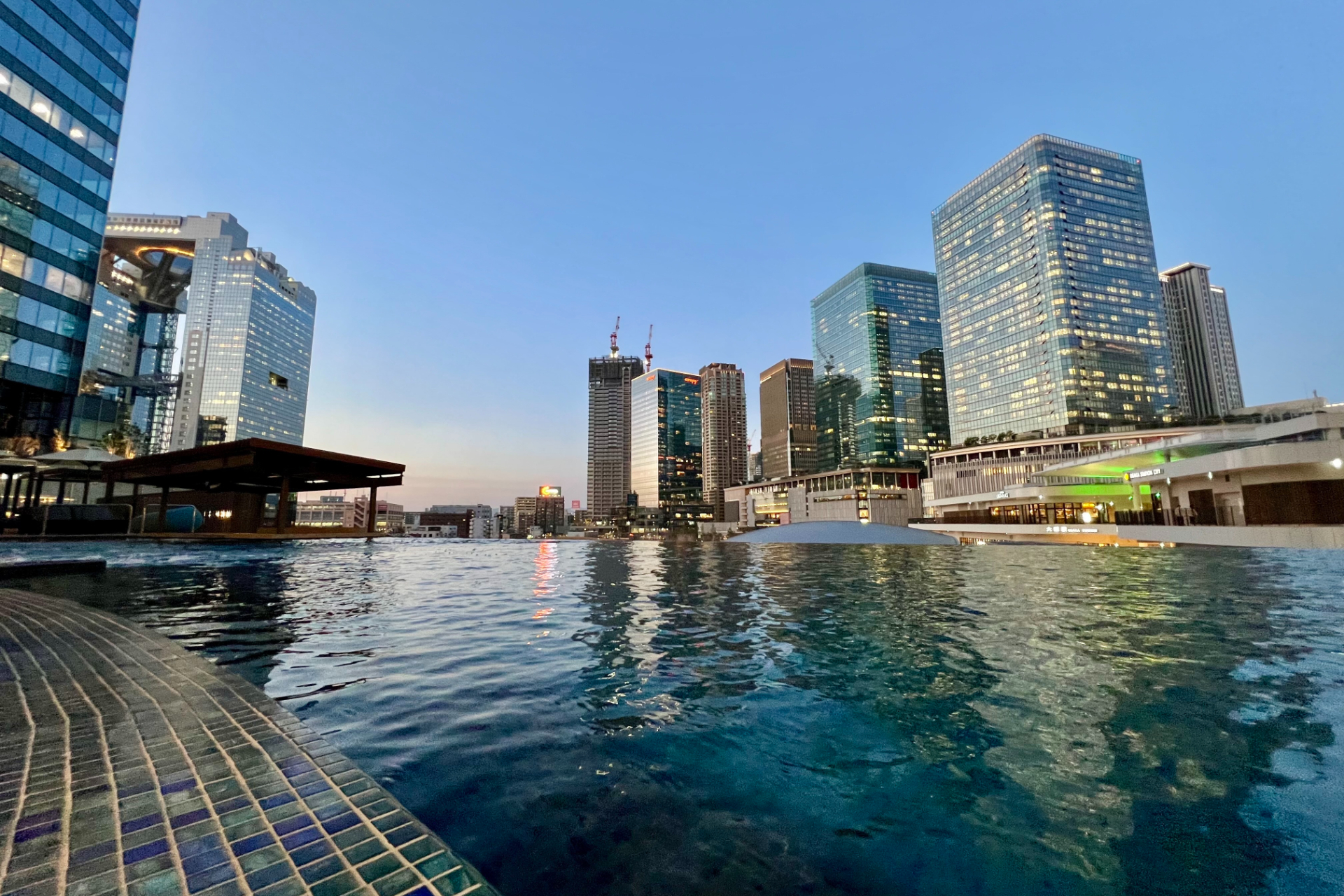 うめきた公園の緑を望む昼間の明るい景色から、マジックアワーはロマンティックなムードに