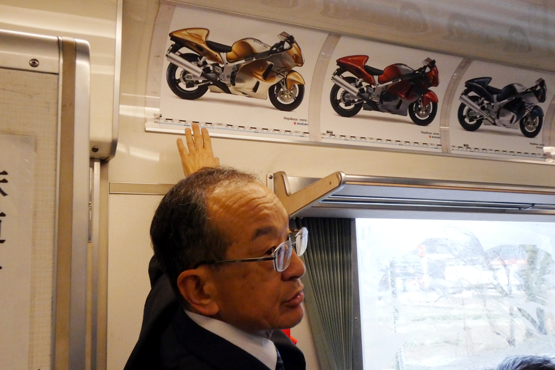 車内で歴代のHayabusaの違いを説明するスズキ二輪 代表取締役社長の濱本英信氏