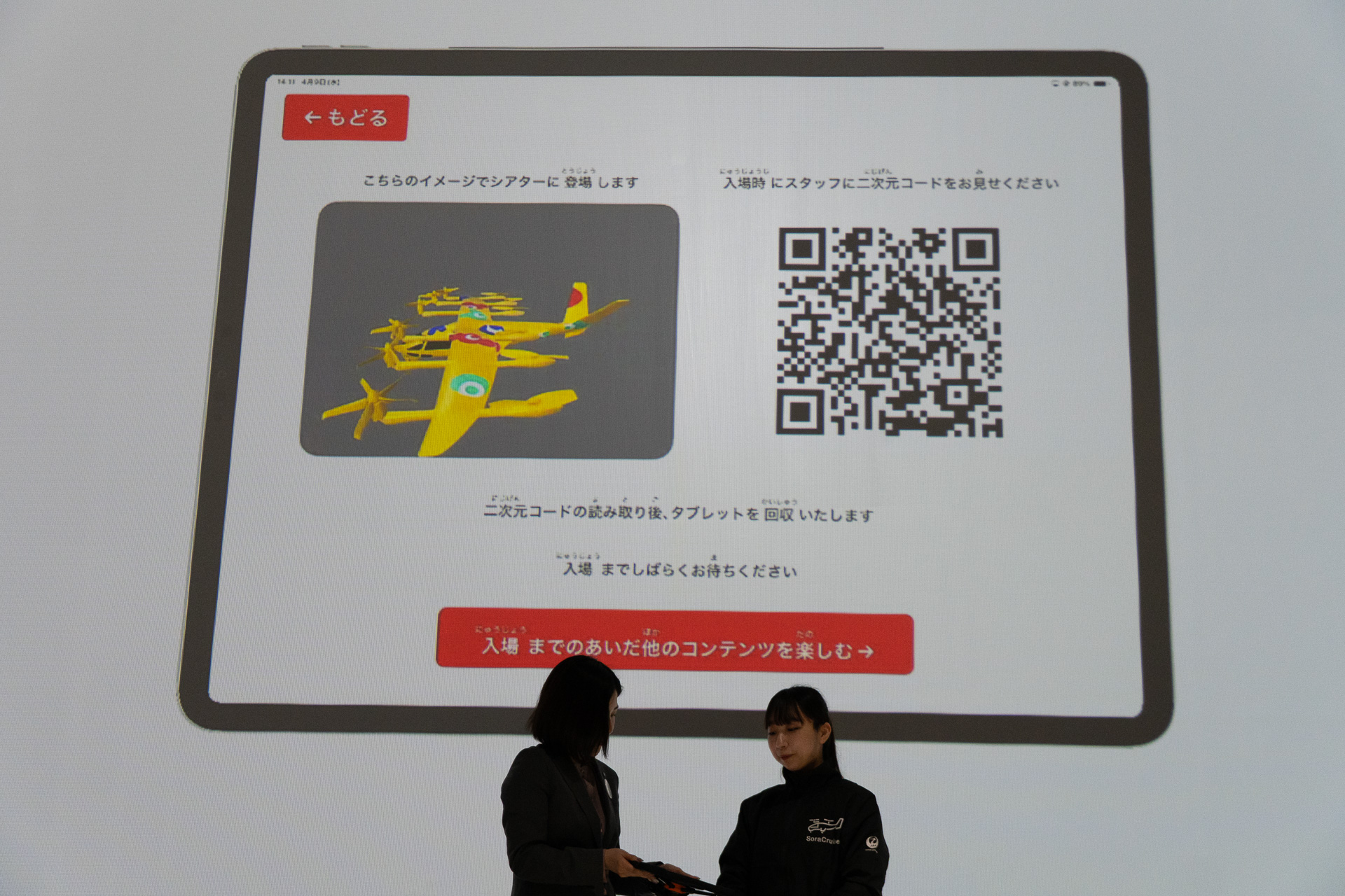 シアター入場を待つ間、タブレット端末で空飛ぶクルマのデジタル塗り絵を体験できる