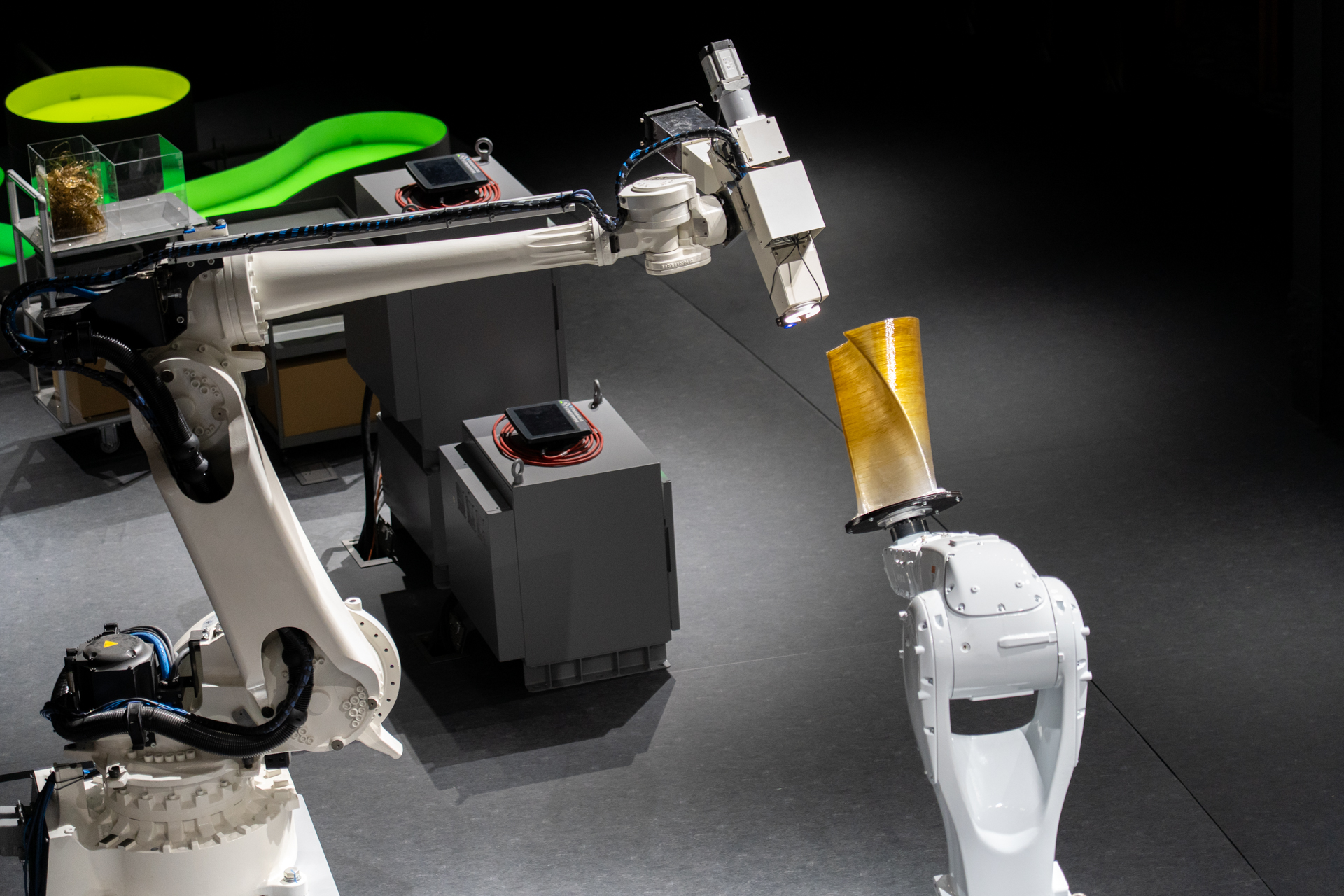 藻類を混ぜ込んだ素材を使って2機のロボットアーム型3Dプリンタがスツールを作っている様子を上から見学