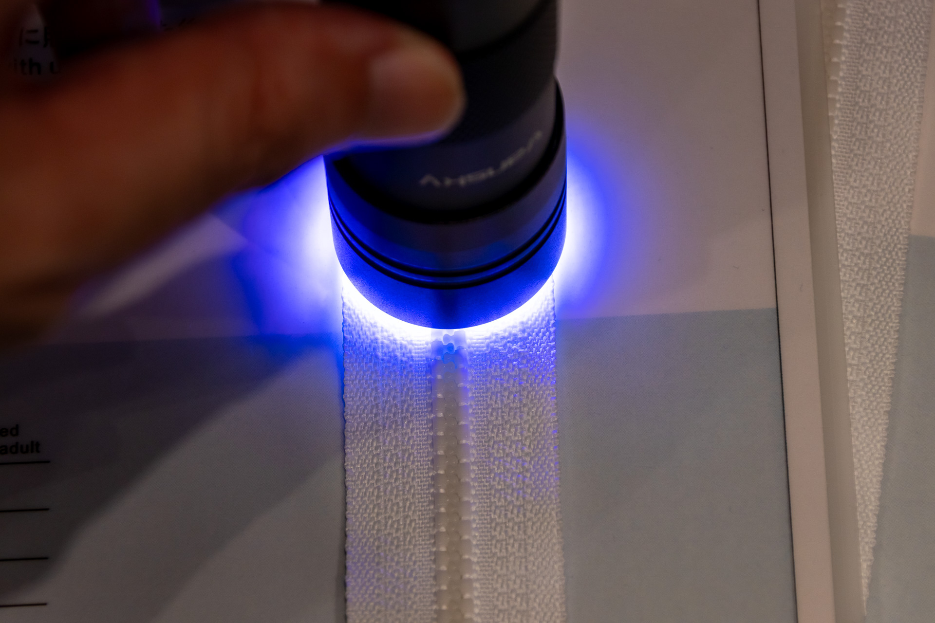 UVライトでファスナーを照らす