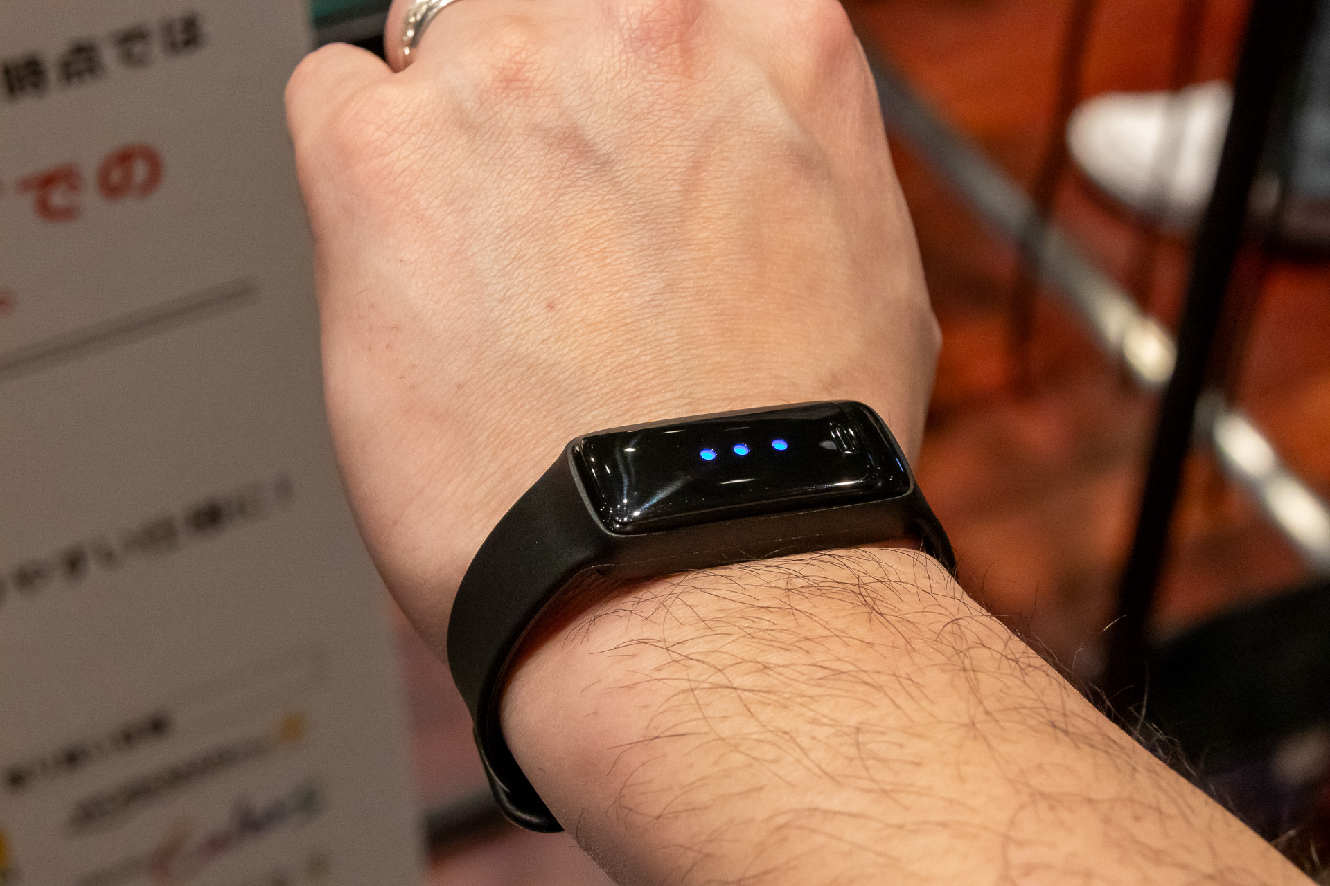 手首に装着したところ。青色は正常で、注意レベルだと黄色に、警告レベルだと赤色に変わる