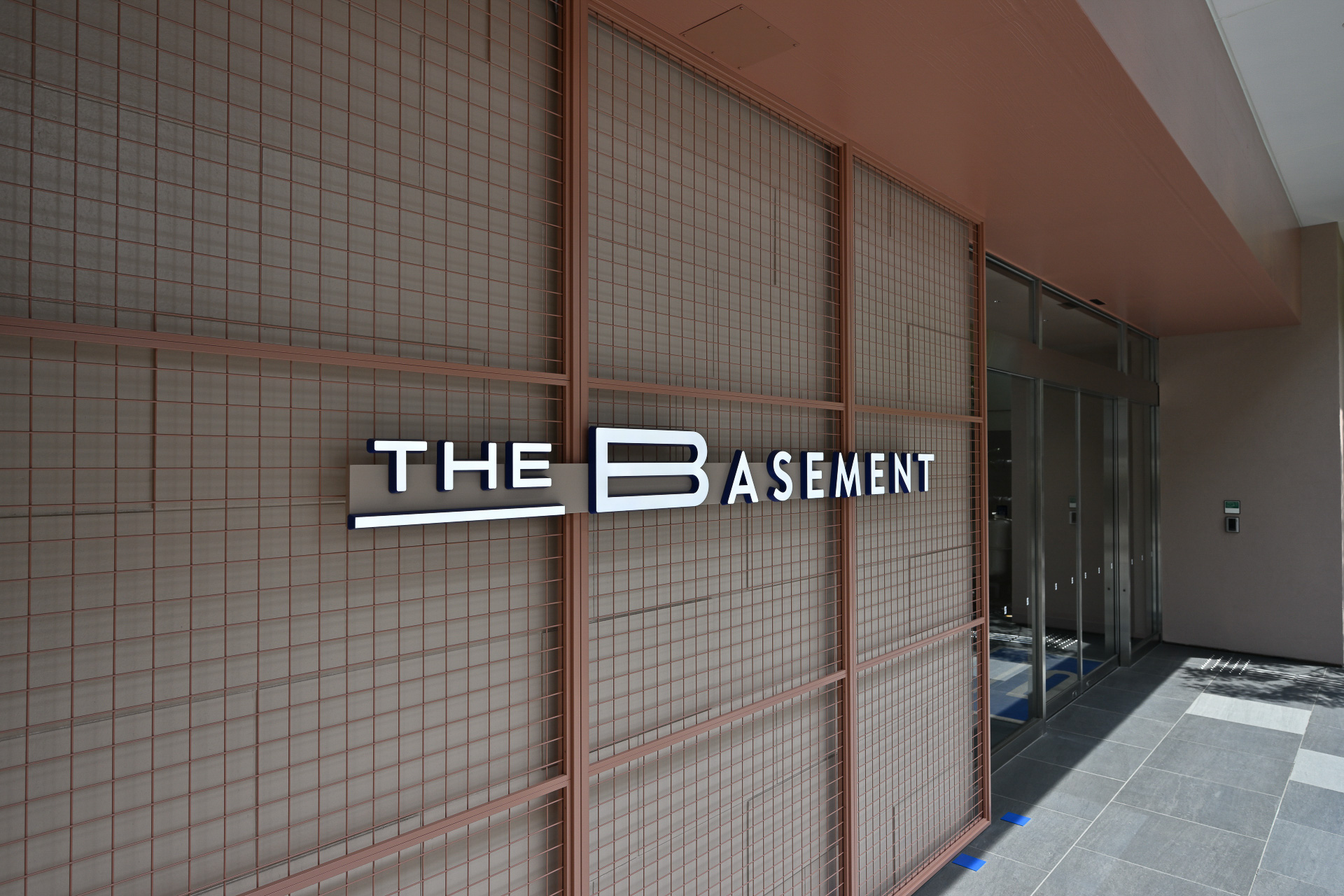 エントランス横に掲げられたシンプルながら主張の強いブランドロゴ