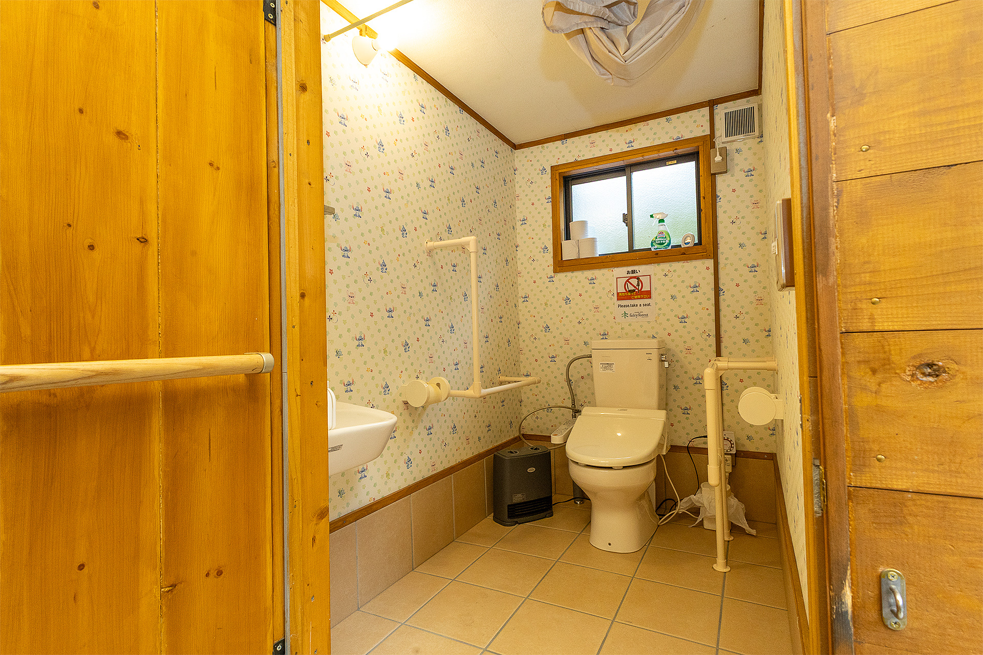 男女兼用の個室。車いすのまま入れるようになっていて幅も広い。両方の壁にはサポート用の手すりがある