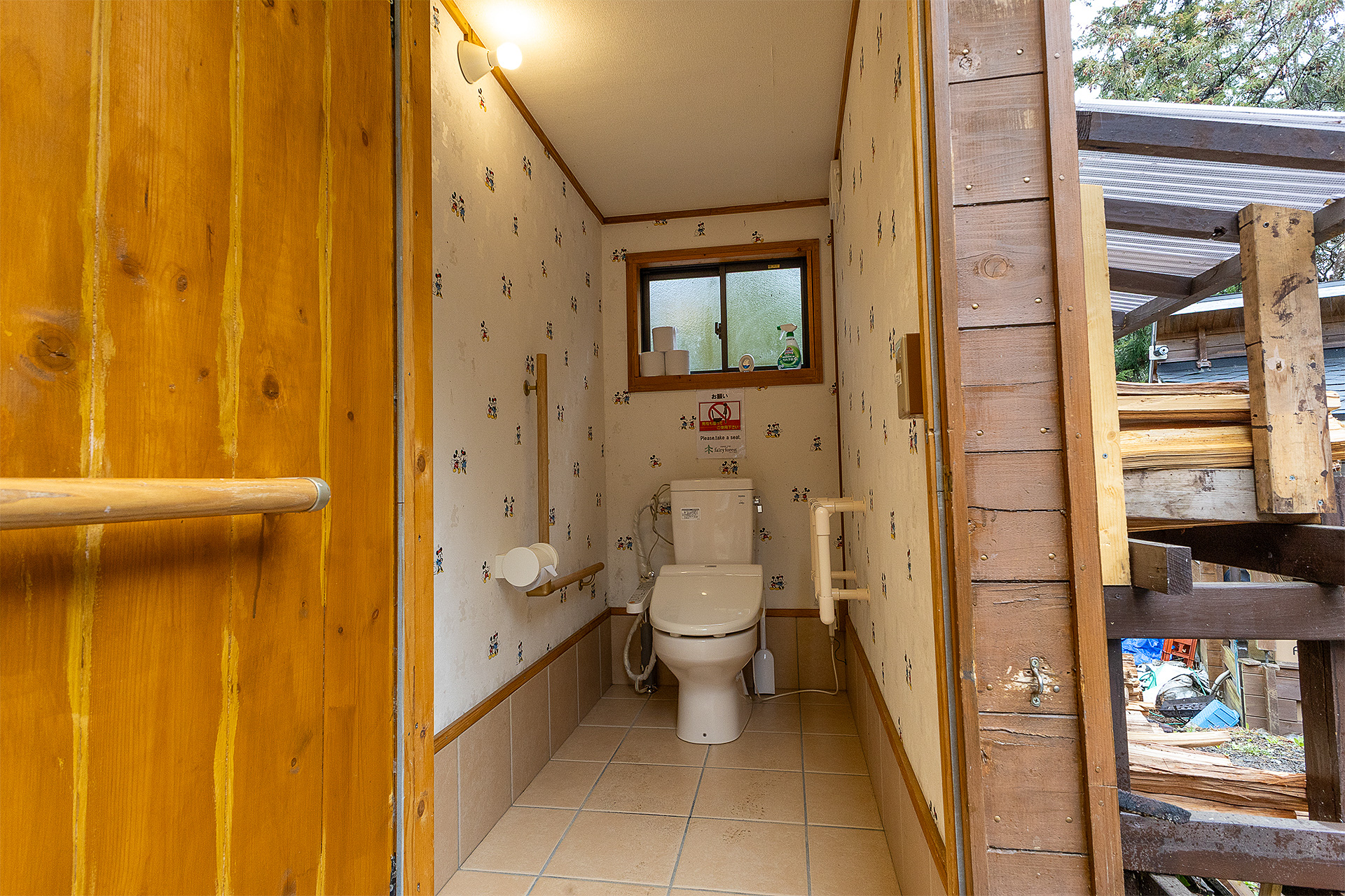 男性用個室。こちらも車いすで入れる。どの個室も壁のスイッチで照明が点くが、車いす利用者や子供が使いやすいよう低い位置にある