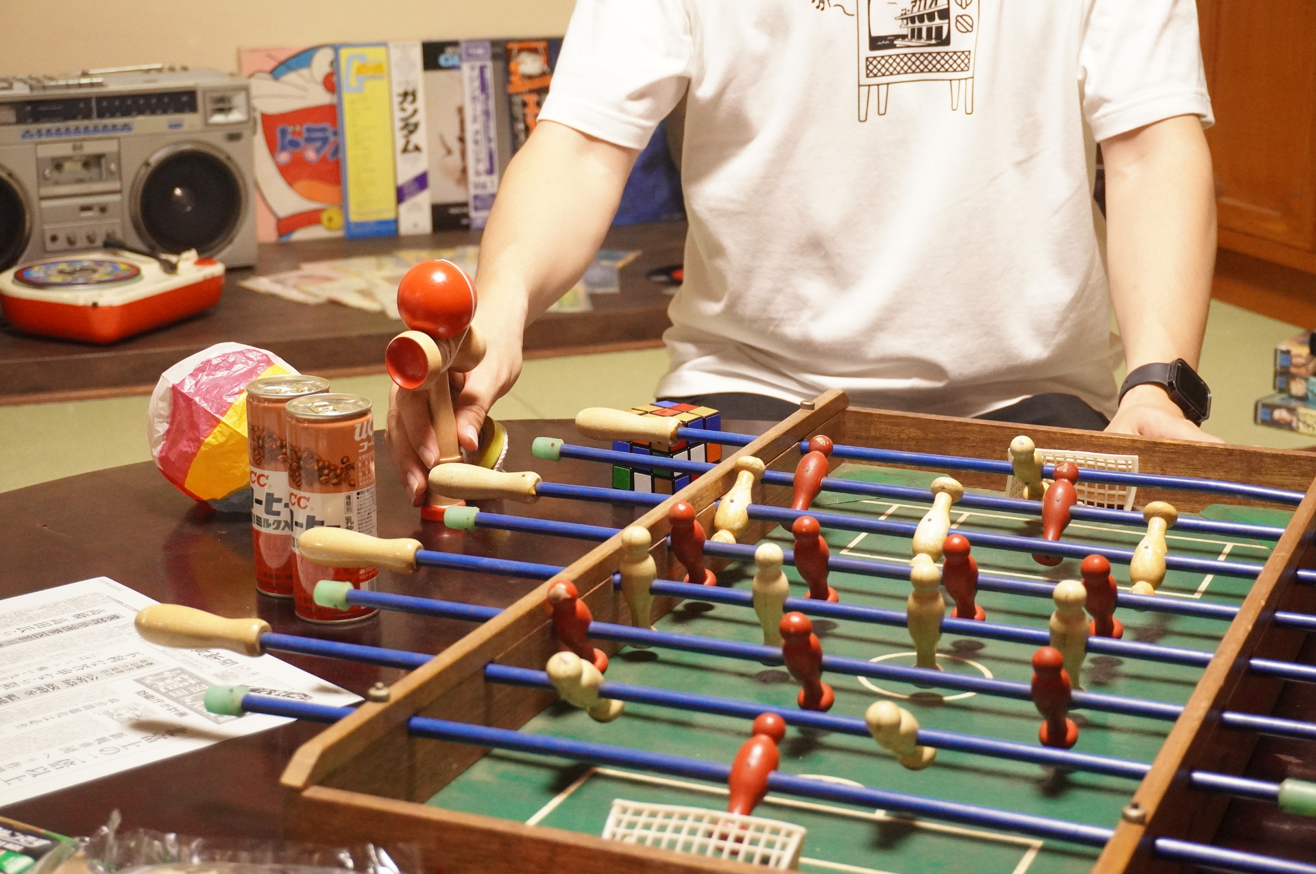 棒をスライドさせたり回転させたりすることで人形を操り得点ゴールを決めるアナログゲーム「サッカー盤」